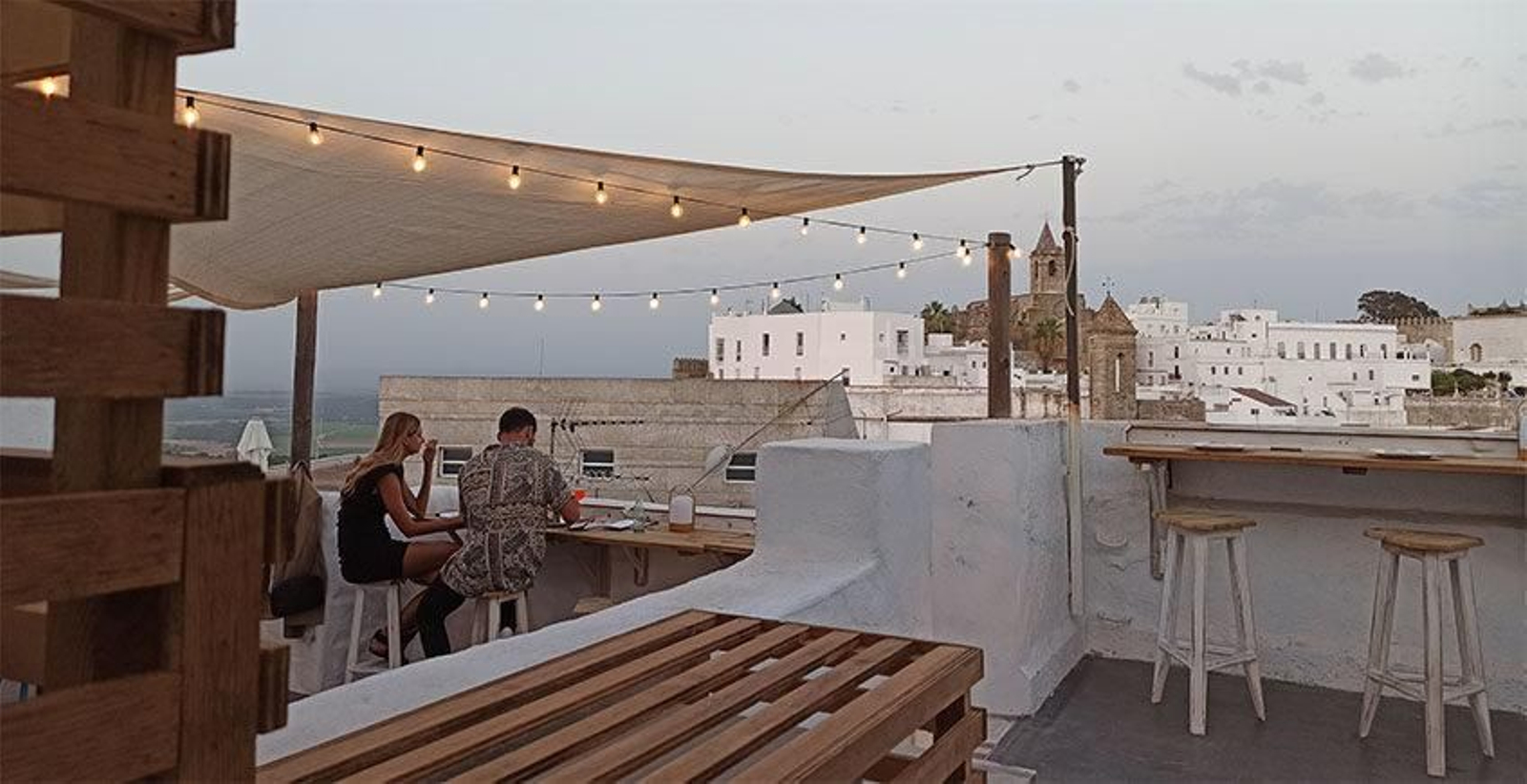Terraza de L'apéro en Vejer, con la iglesia del Divino Salvador al fondo.