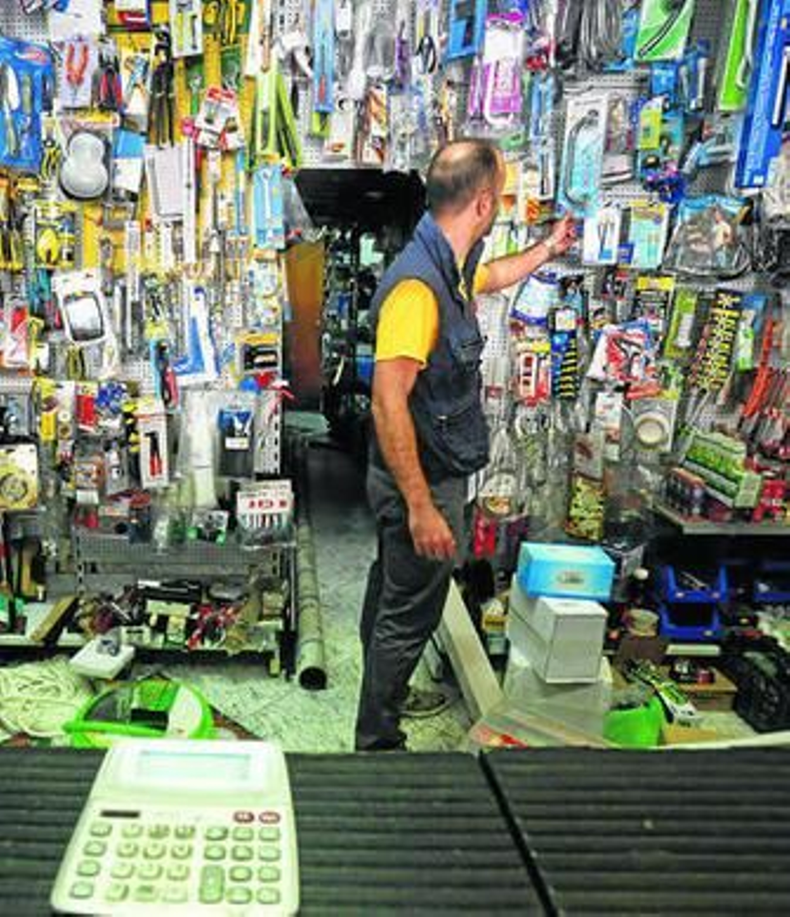 Un autónomo coge uno de los productos de su ferretería.
