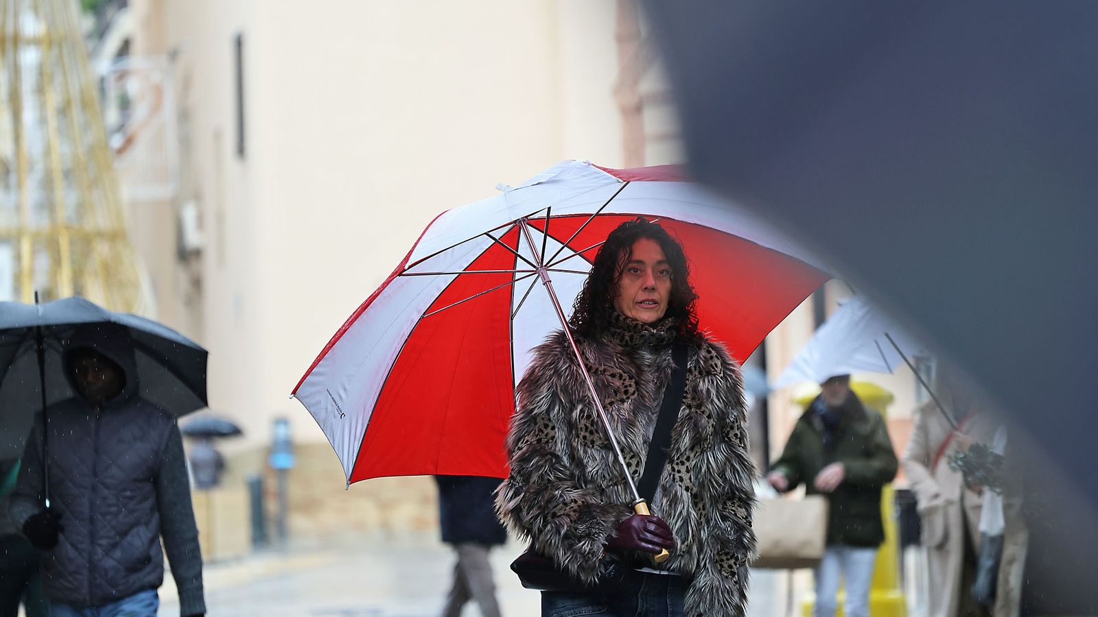 Una persona con paraguas en Huelva.