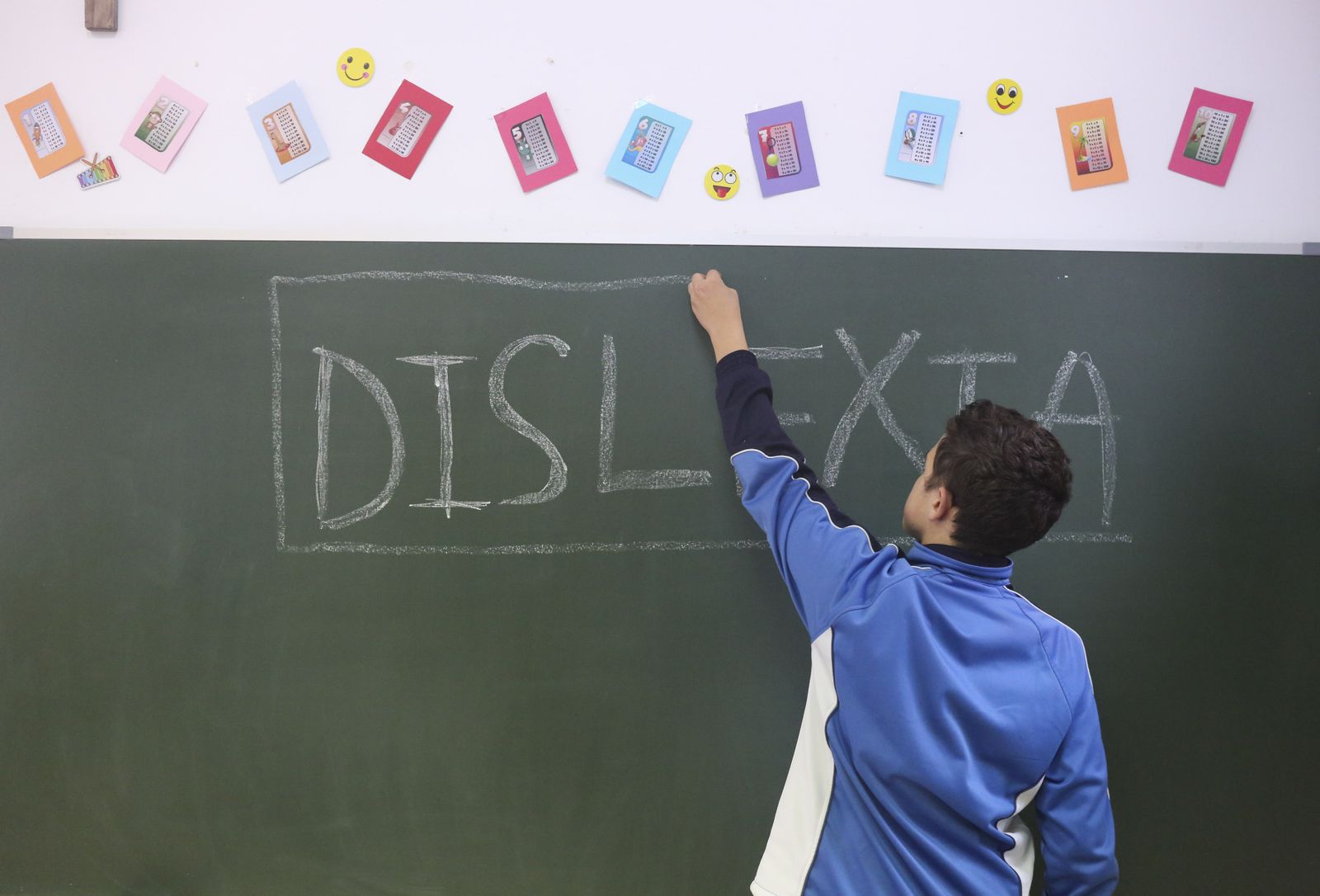 Un niño escribe en una pizarra.