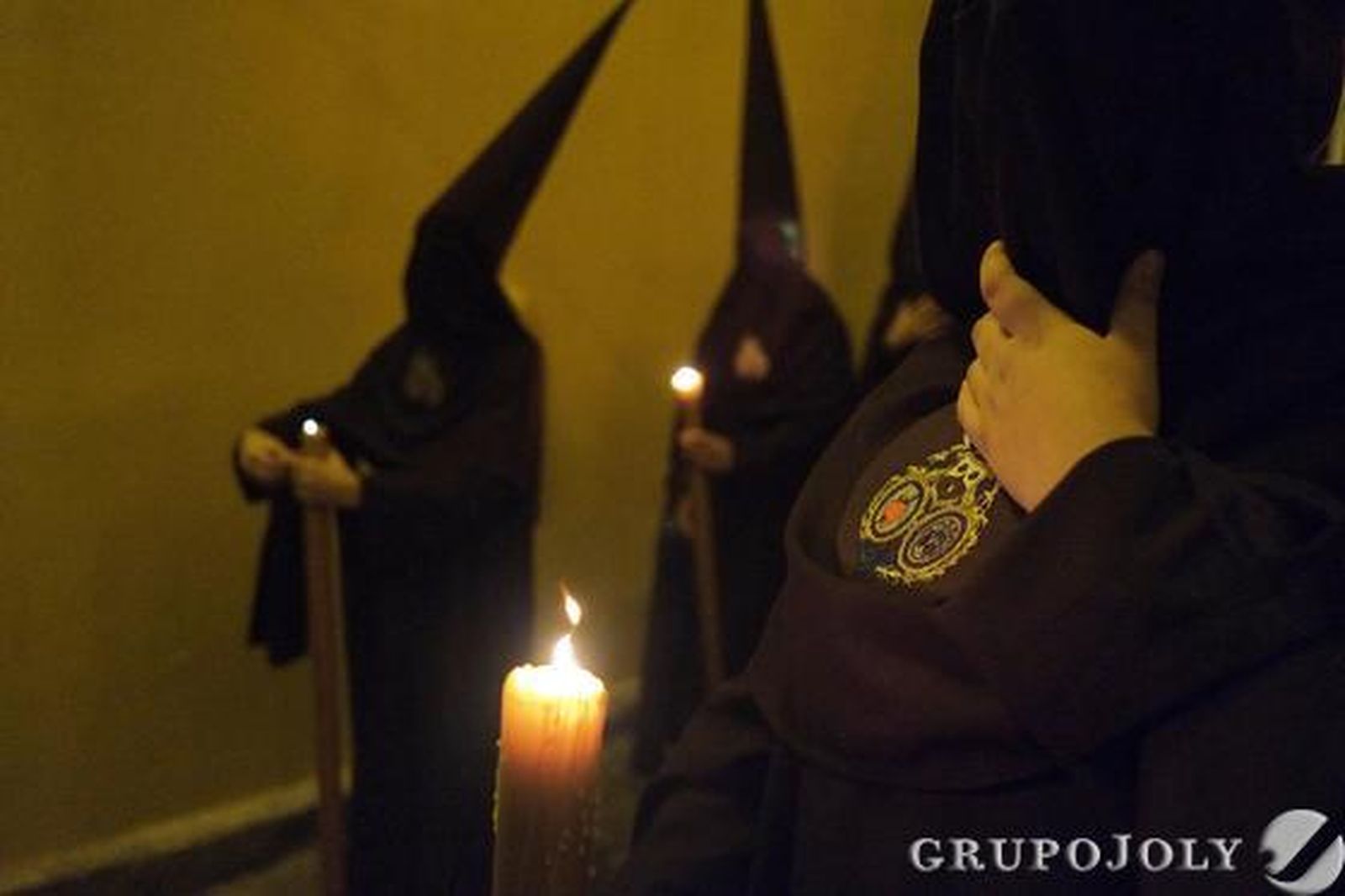 Hermanos de La Lanzada portan sus cirios encendidos cuando empiezan a rodear la basílica del Carmen camino de la Carrera Oficial.

Foto: Manu Garcia