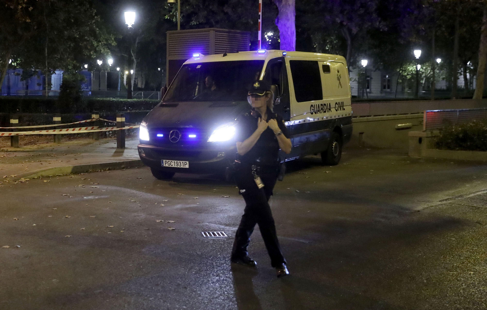 Una policía vigila la salida de la Audiencia Nacional del furgón que lleva a los líderes de Òmnium y ANC.
