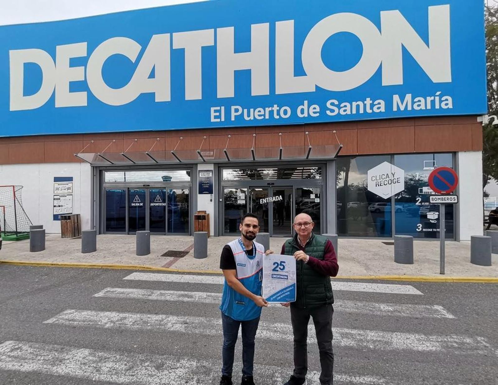 El director de la tienda y el concejal de Deportes, con el cartel del 25 aniversario.