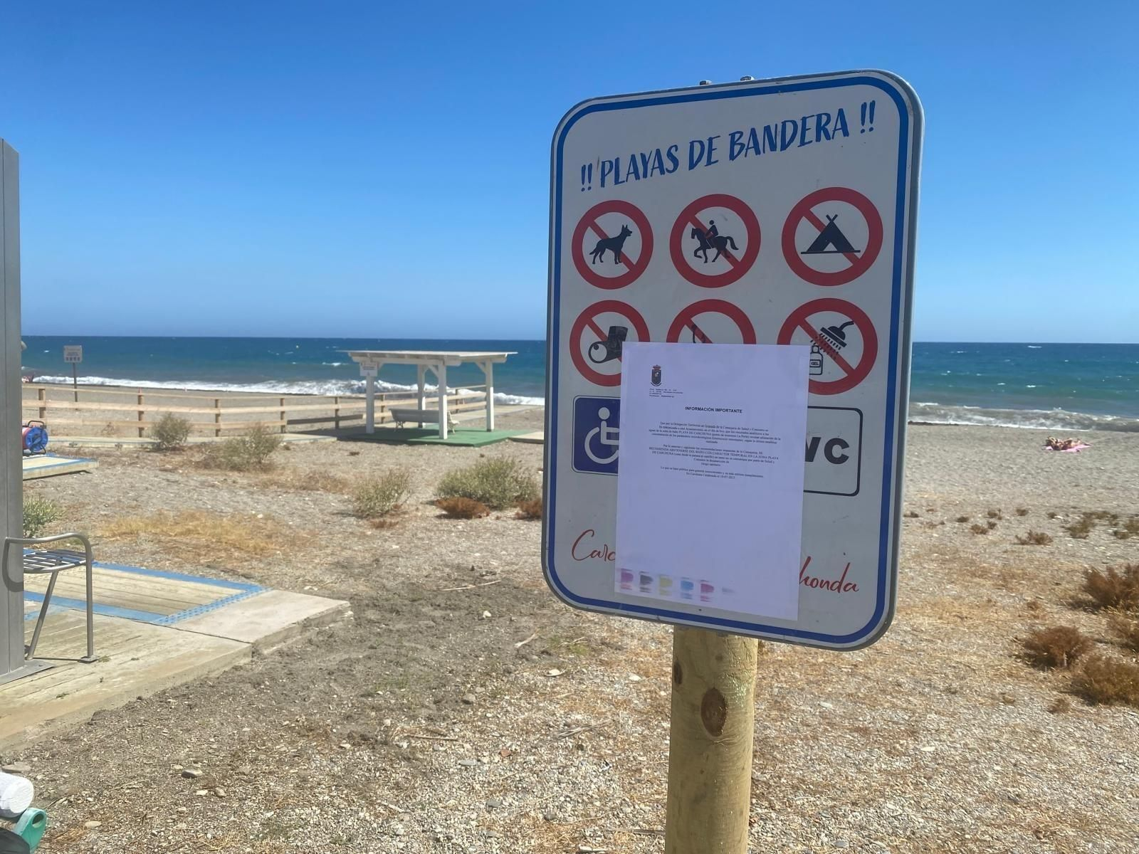 Un cartel anunciando la prohibición de baño en Carchuna hace dos semanas