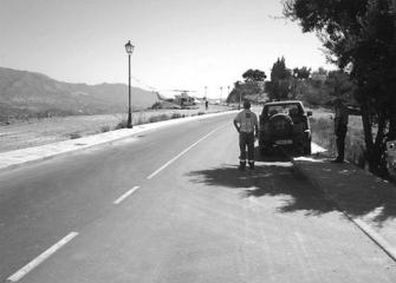 El helicóptero que participó en la búsqueda, y dos miembros del dispositivo de rastreo, ayer en Mijas.