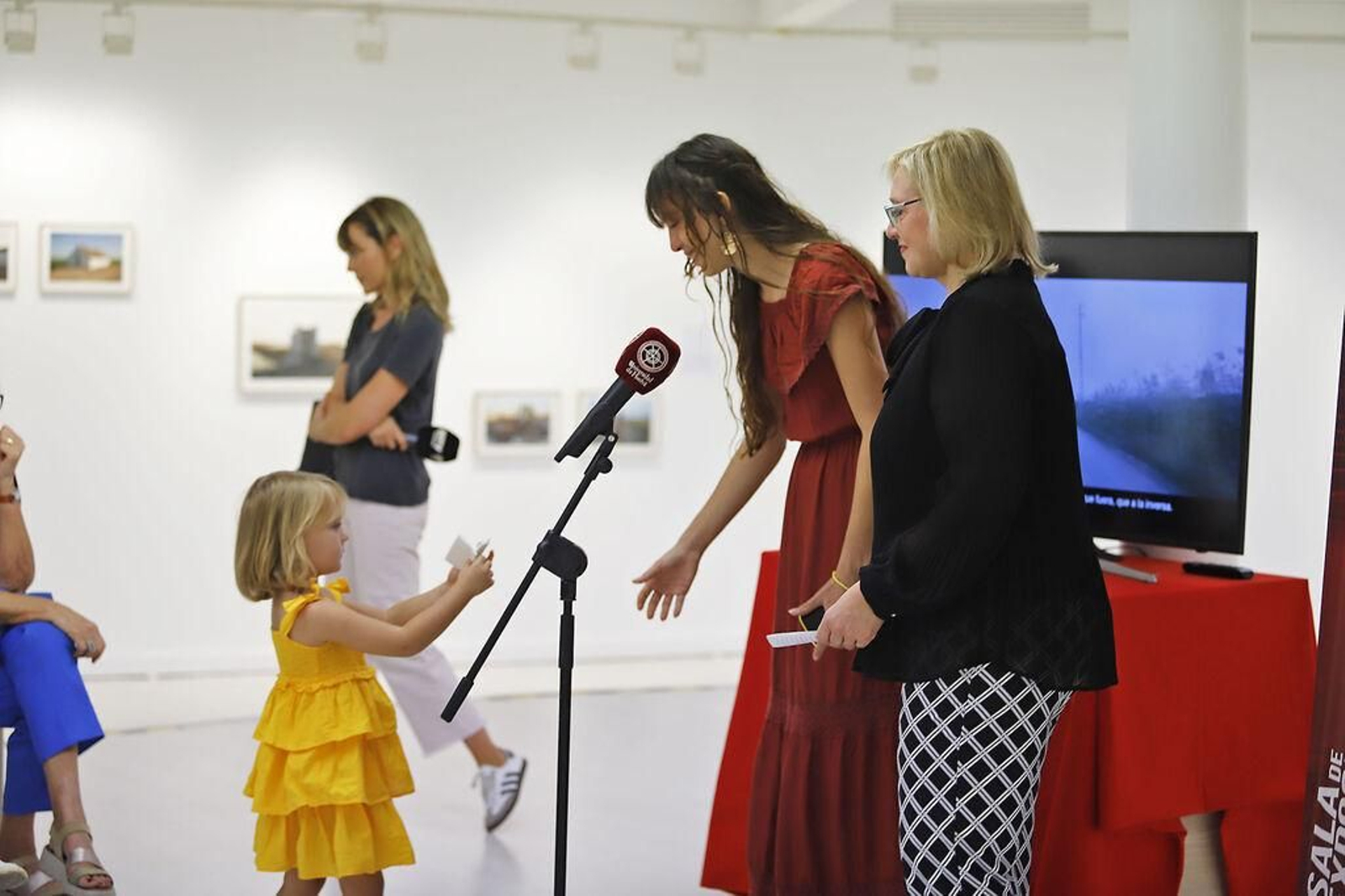 Una niña entrega una hoja a la artista Palacios-Ferri Una niña entrega una hoja a la artista Palacios-Ferri