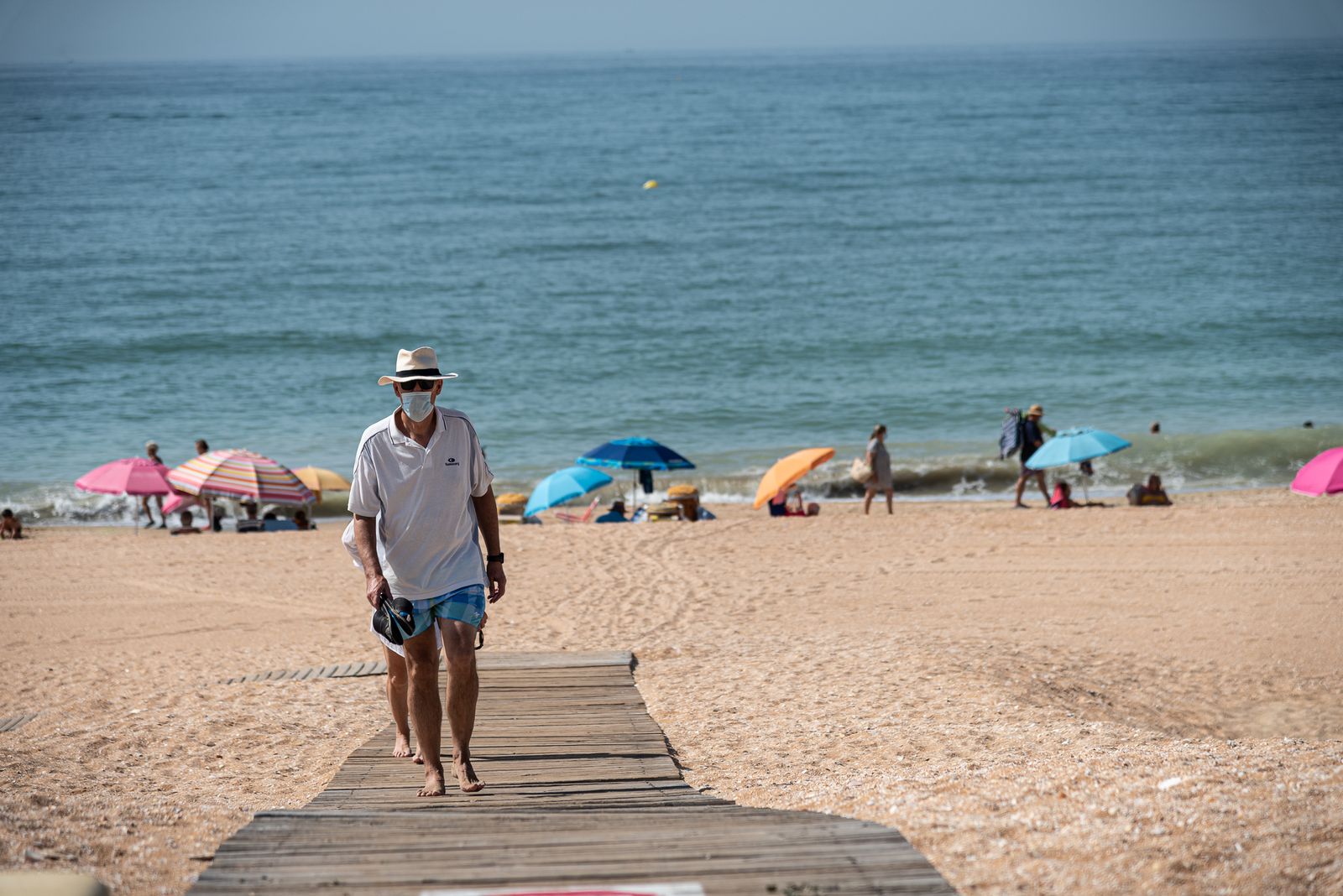 Una hombre sale de una playa onubense.