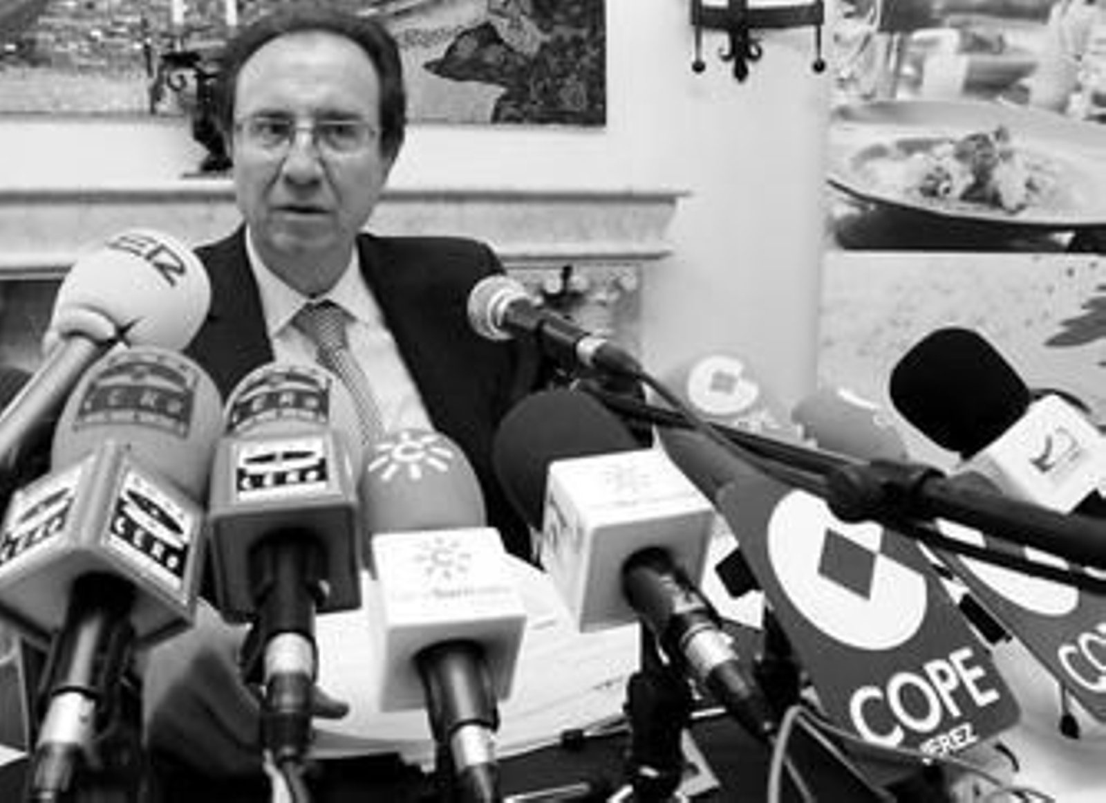 Víctor López, portavoz del grupo de Nuchera, rodeado de micrófonos durante la rueda de prensa.