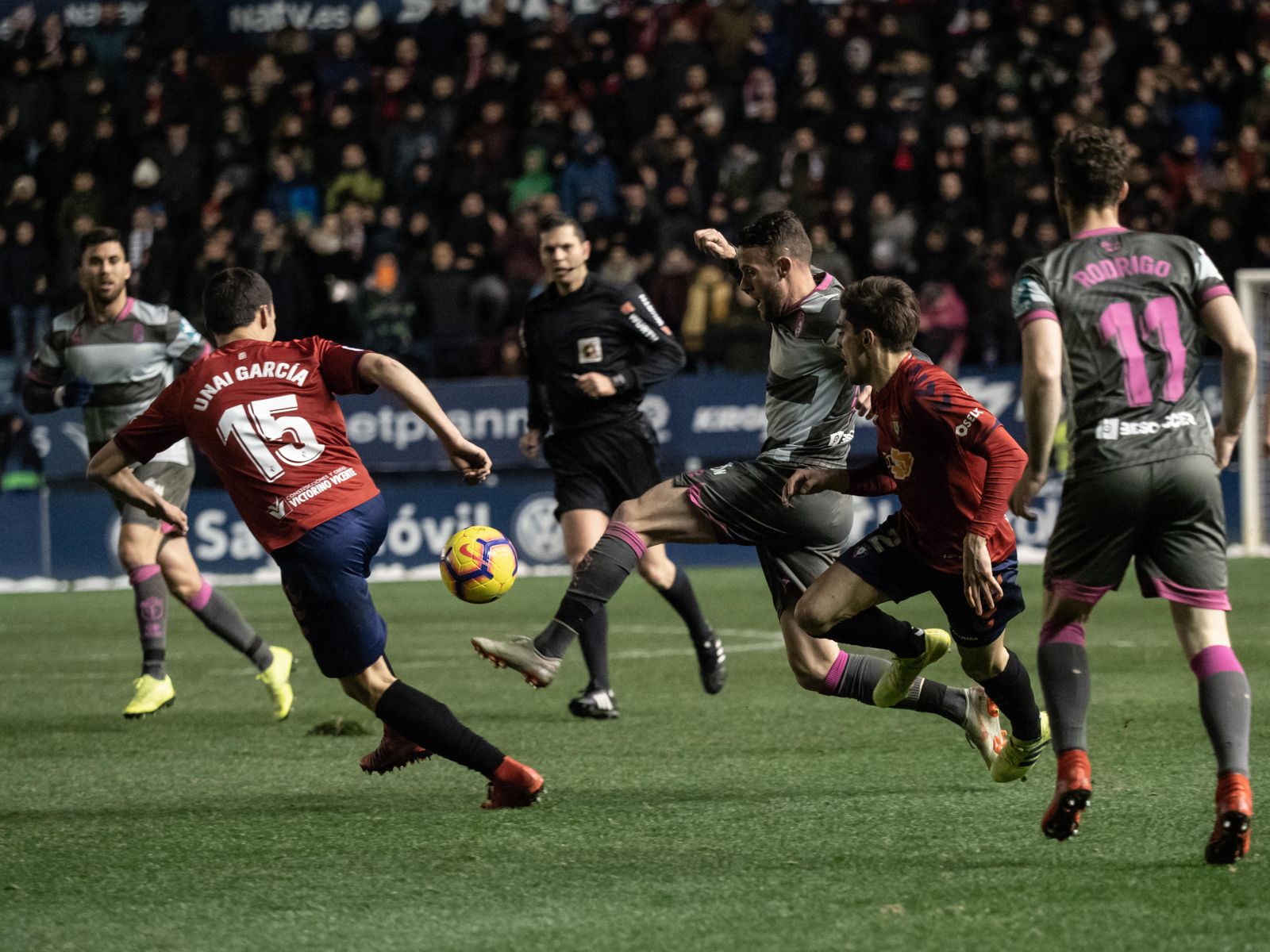 Quini trata de zafarse de la presión de dos contrarios de Osasuna.
