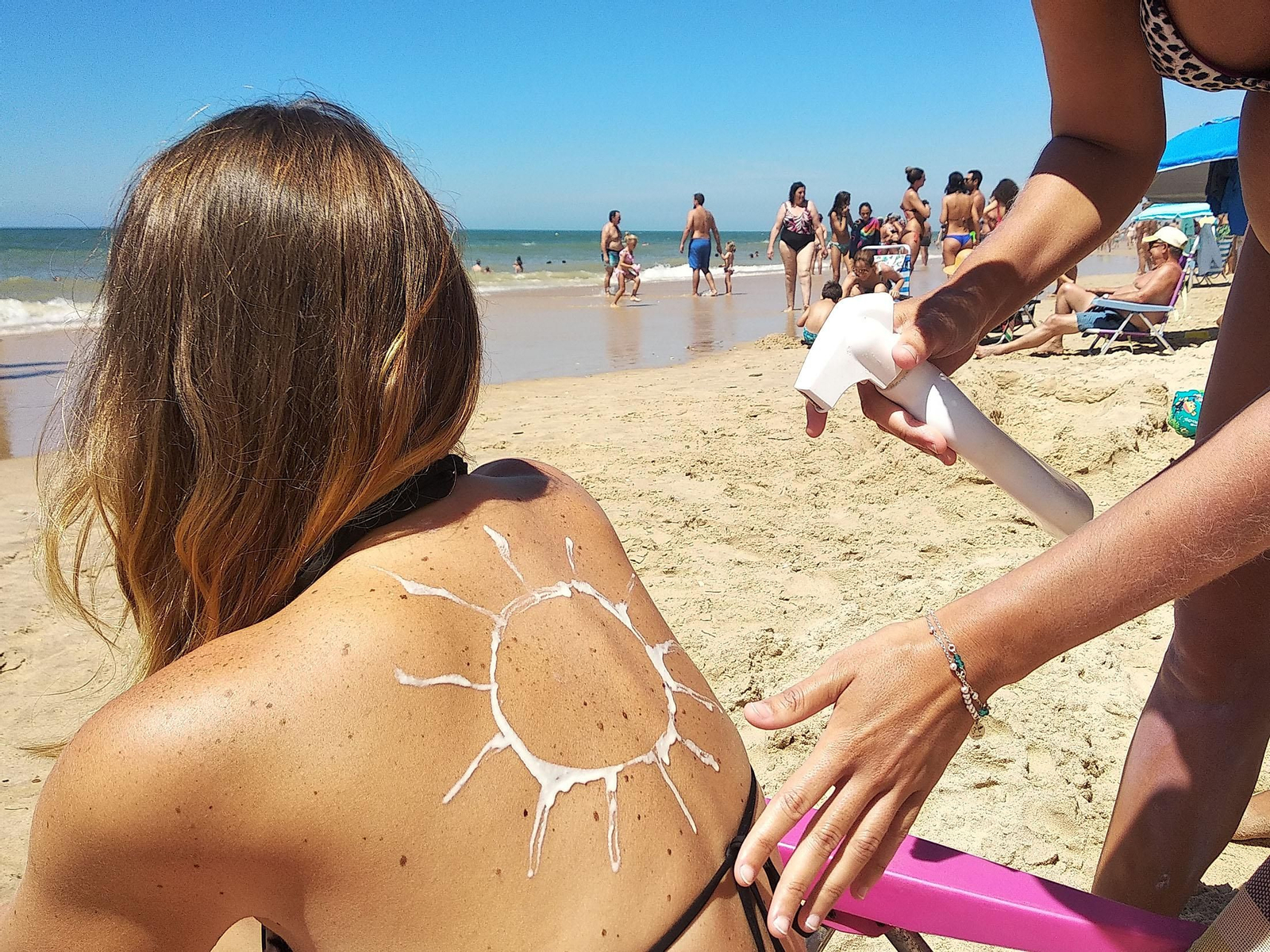 Una bañista se protege del sol en una playa de Huelva.