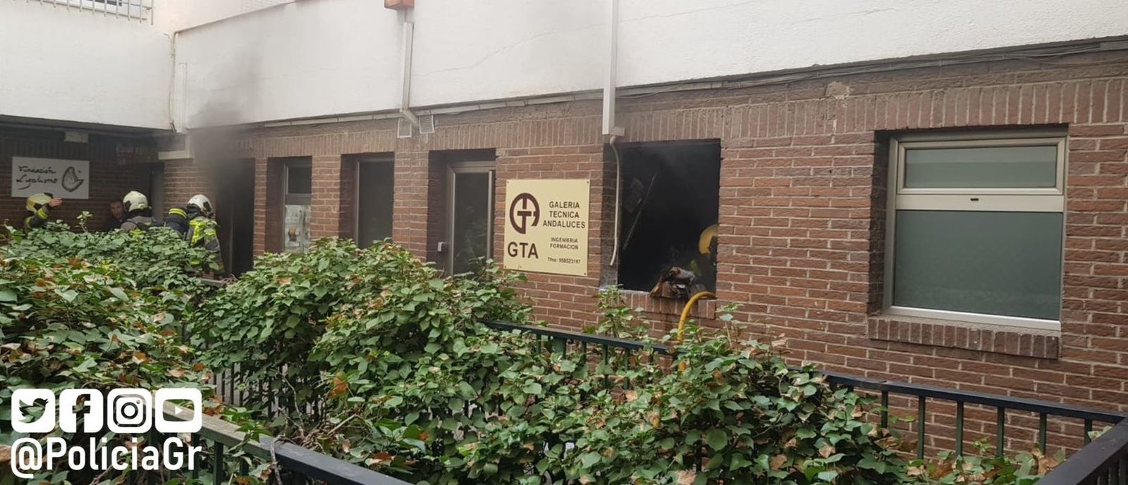 Imagen del humo saliendo de los bajos comerciales donde han intervenido los bomberos de Granada