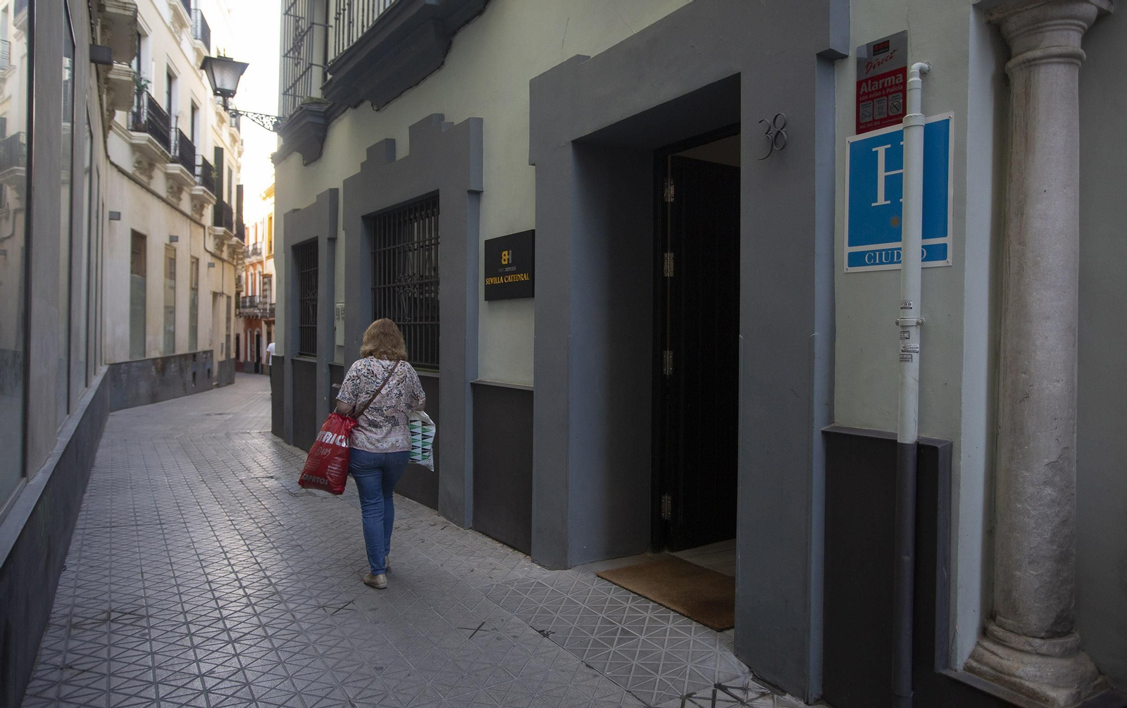Una mujer pasa por la puerta del hotel de una estrella, en el número 38 de la calle Álvarez Quintero.