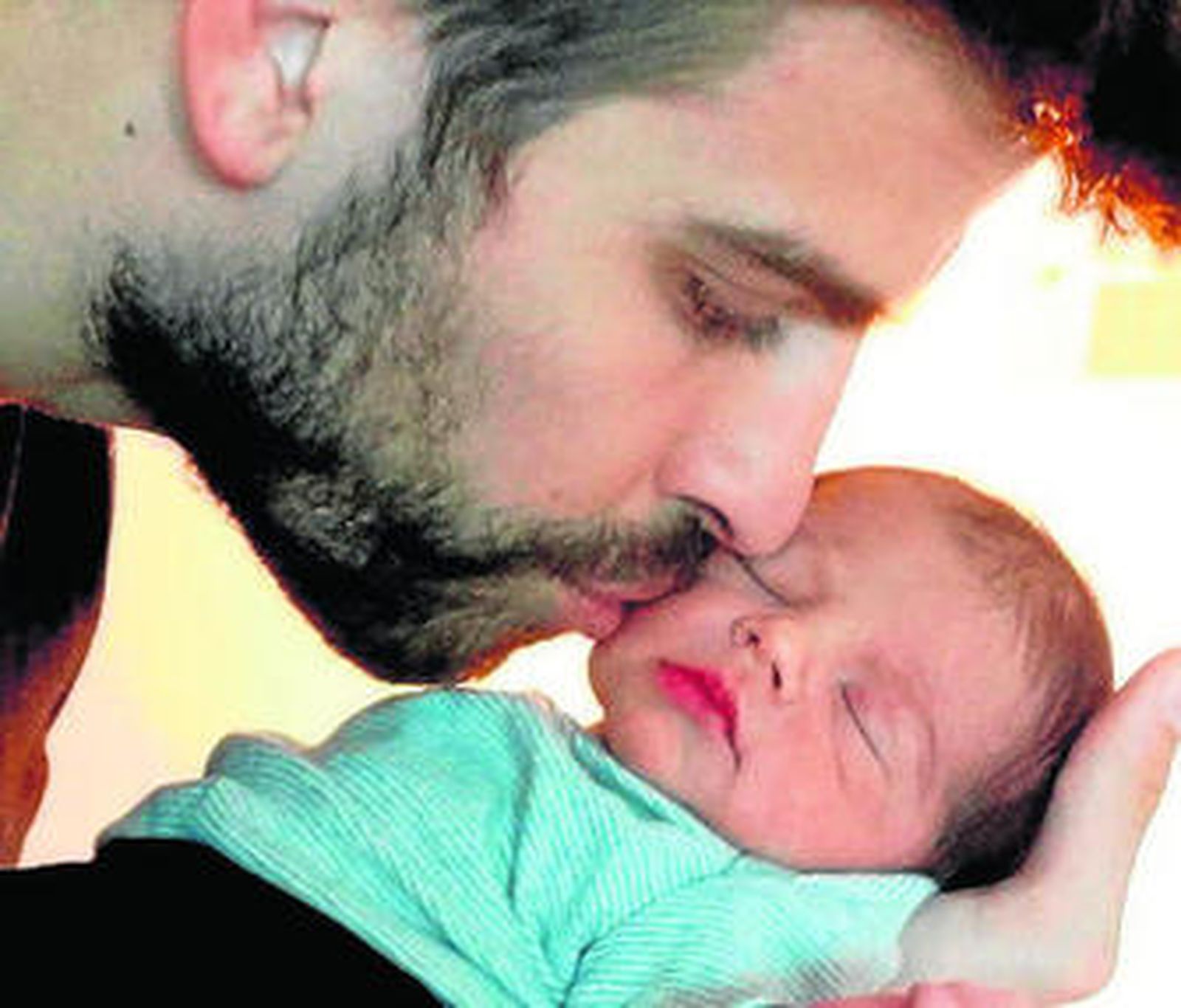 Piqué besa a su bebé mientras éste duerme plácidamente.