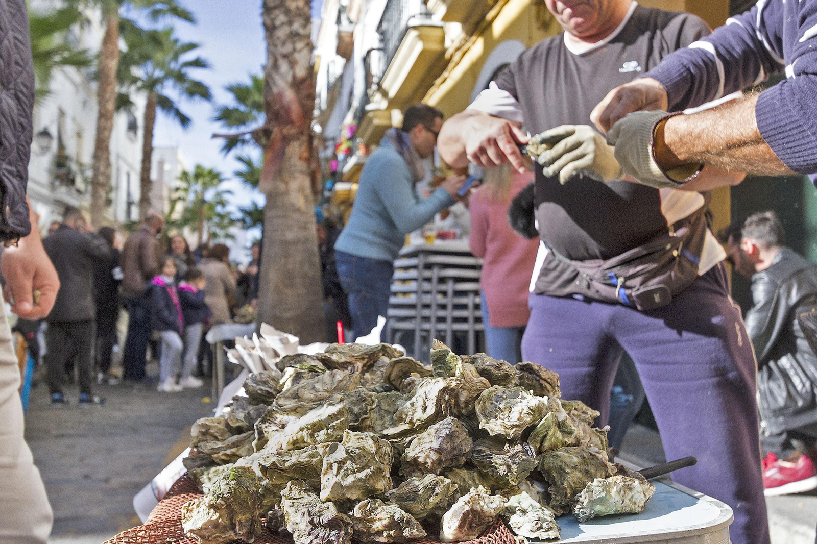 Un par de hombres, abriendo ostiones en plena calle de La Palma en el día de ayer.