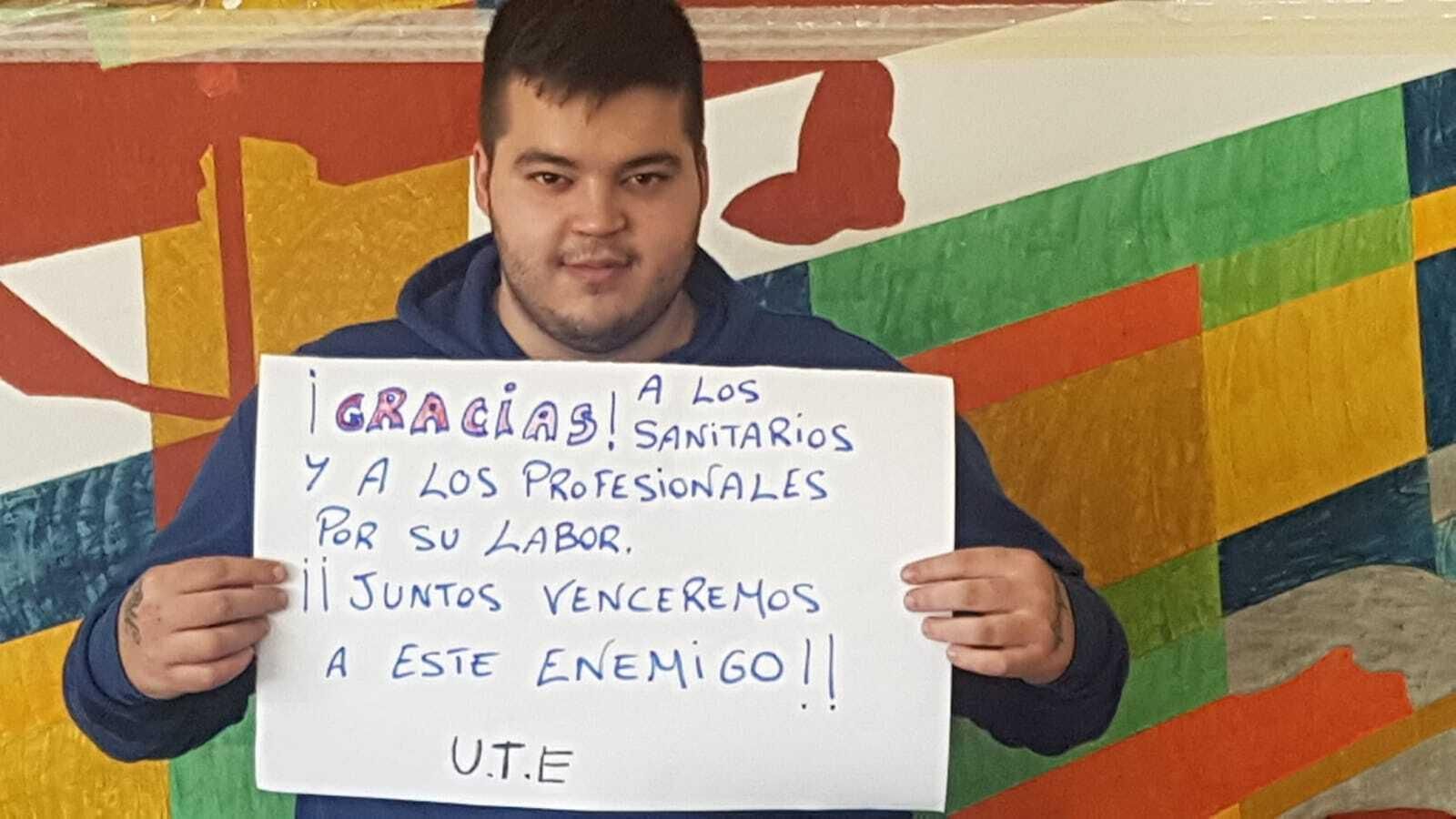 Un internos de la Unidad Terapéutica y Educativa (UTE) con un cartel elaborado para enviar un mensaje de tranquilidad.