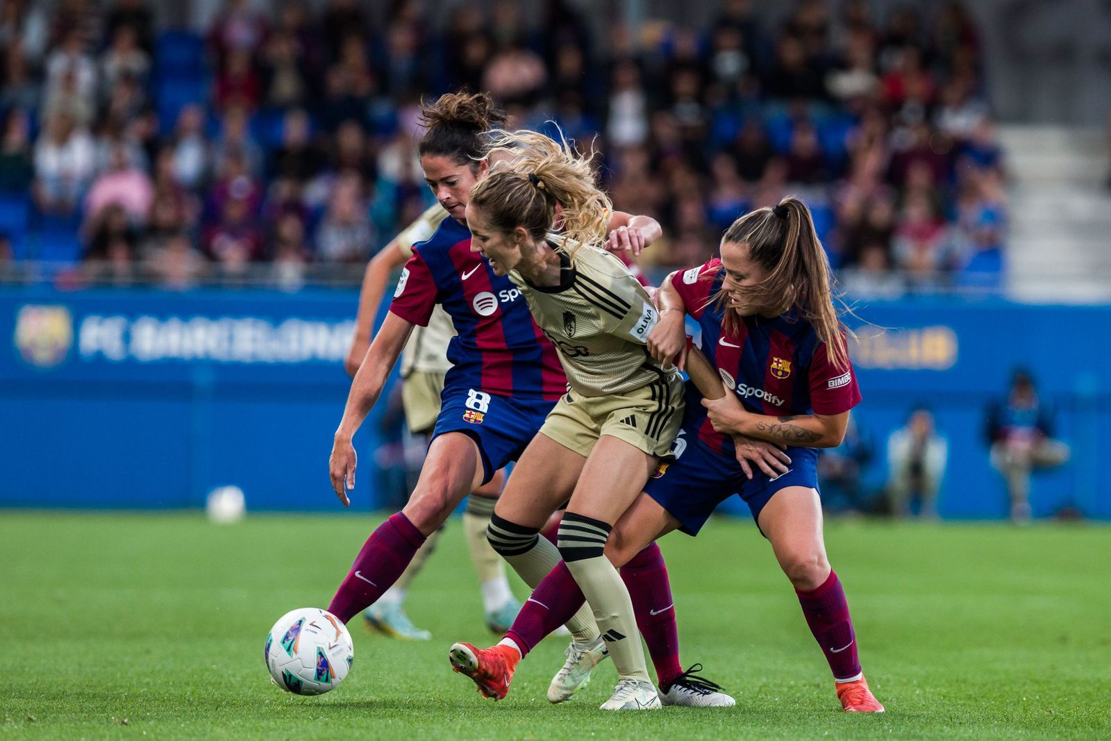 Lauri brega con dos jugadoras culés en el partido en Barcelona