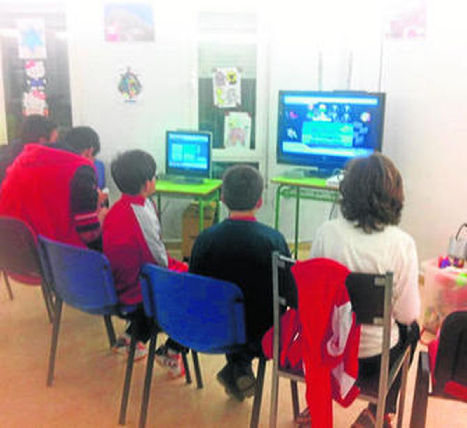 Un grupo de niños se entretienen con video juegos.