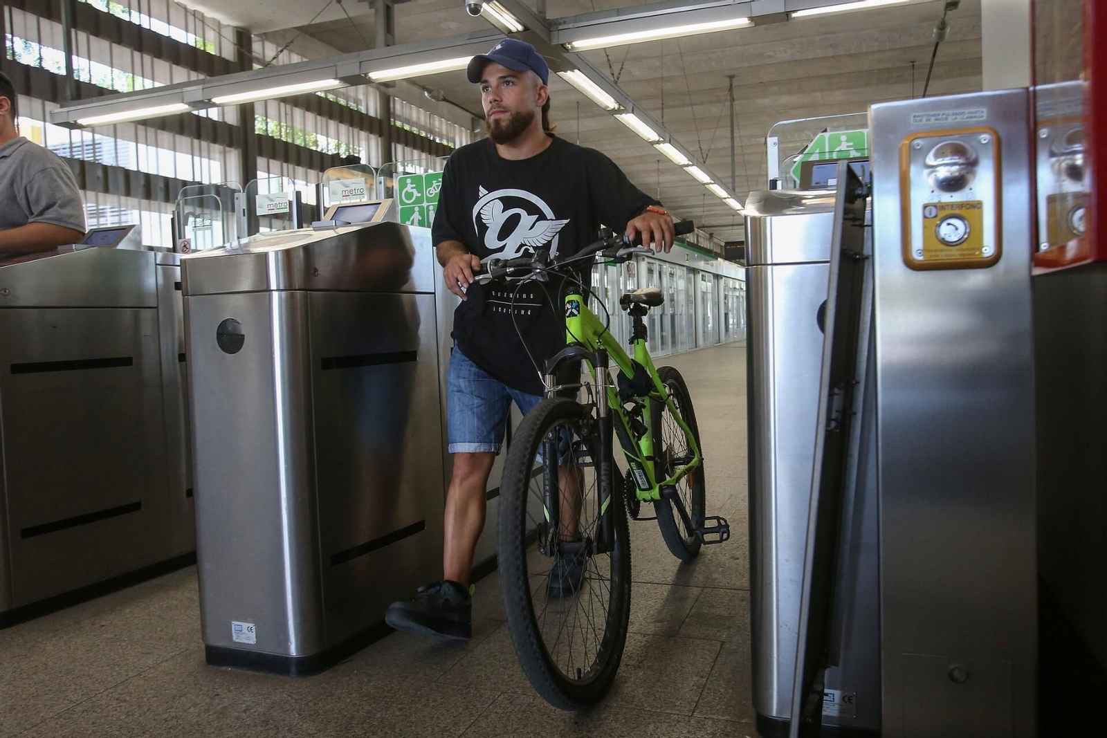 Un joven con bicicleta en una estacion de Metro.
