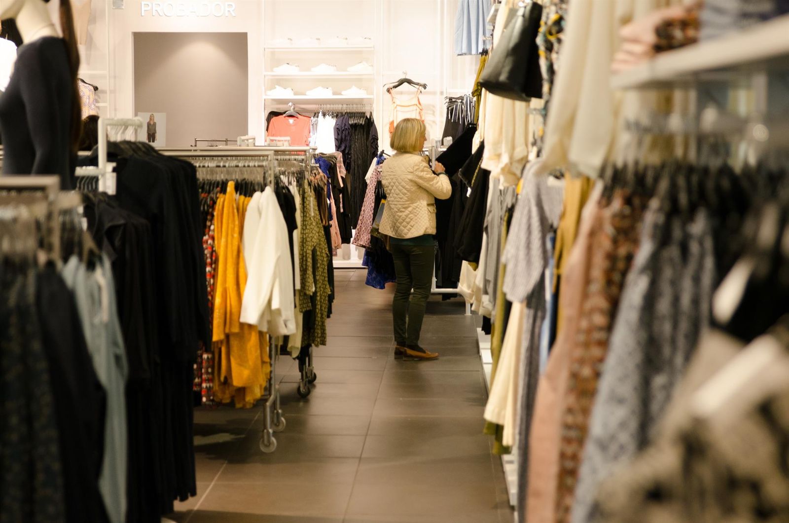 Una mujer comprando en una tienda de ropa.
