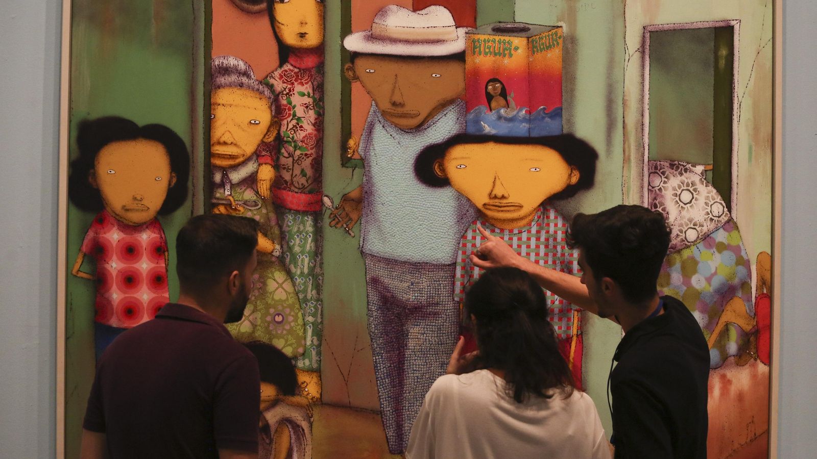 Varios asistentes contemplan una obra pictórica de la muestra 'Osgemeos', este miércoles.