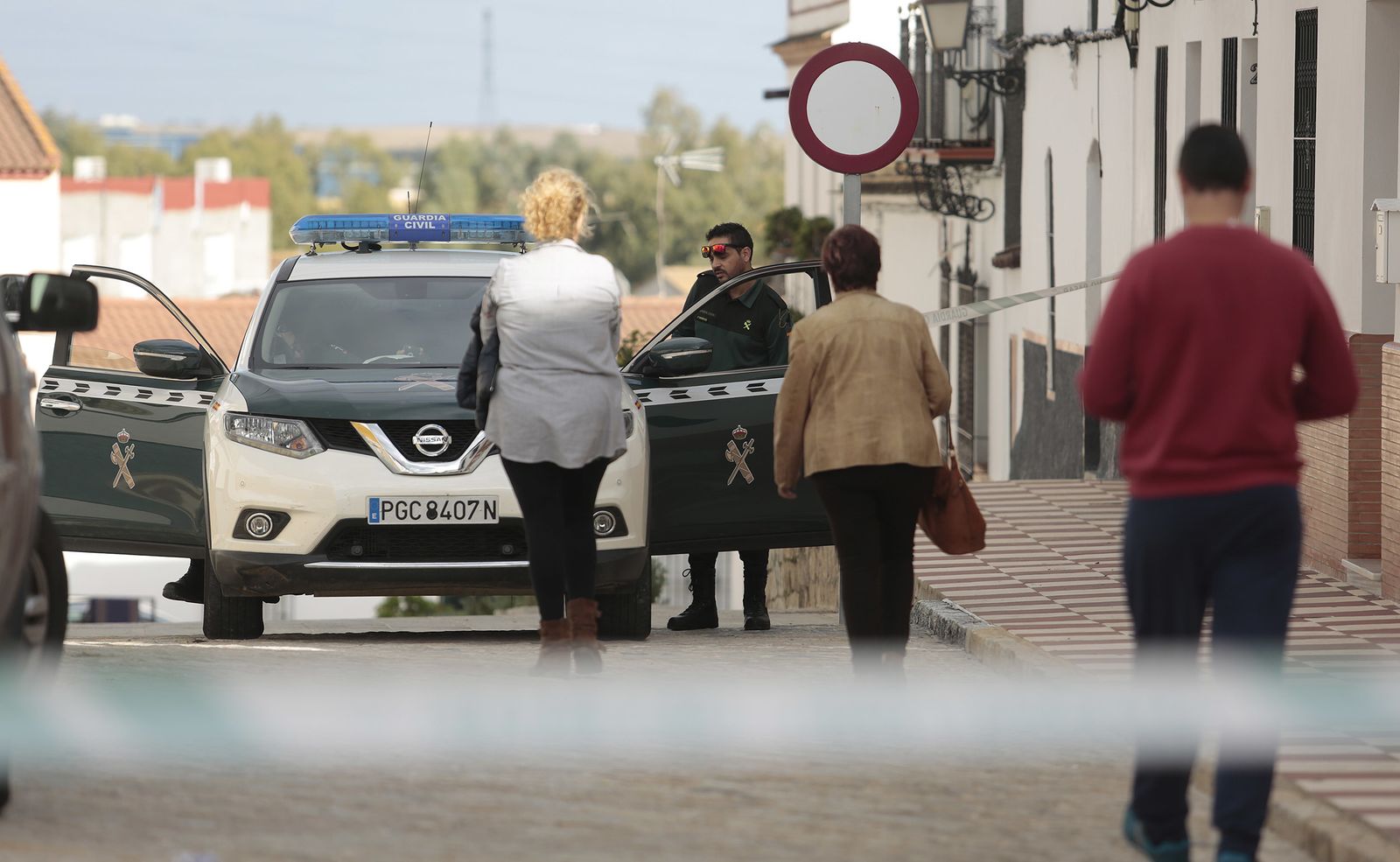 Amigos de la víctima se dirigen hacia un patrullero de la Guardia Civil.