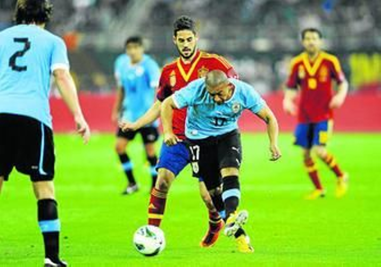 Isco intenta quitarle el esférico al jugador de Uruguay Ríos.