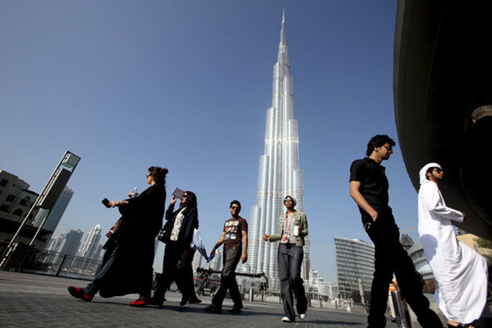 Un grupo de dubaitíes pasea bajo la Burj Dubai. / Reuters