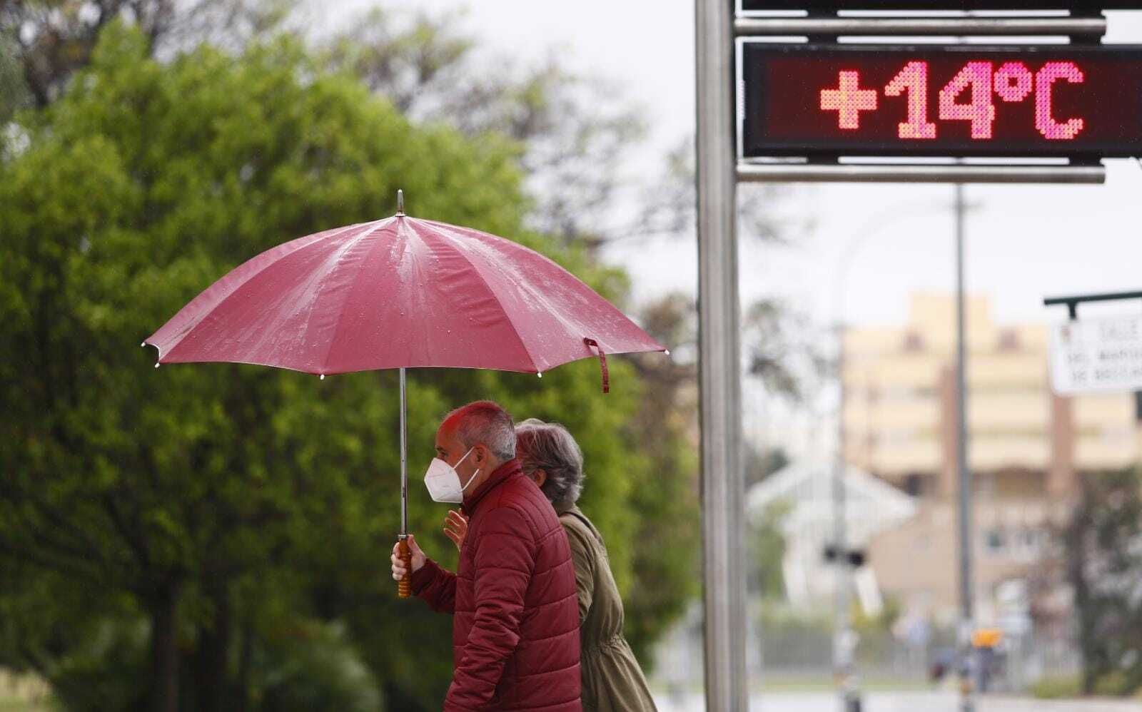 Dos viandantes se resguardan de la lluvia.