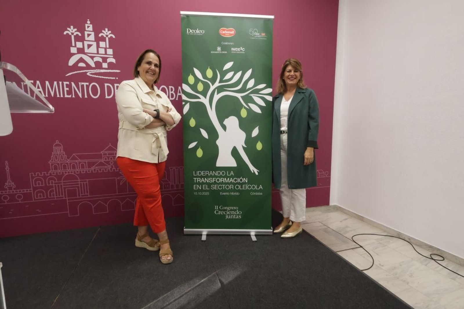 Blanca Torrent y Pilar Larrea, junto al cartel del congreso.