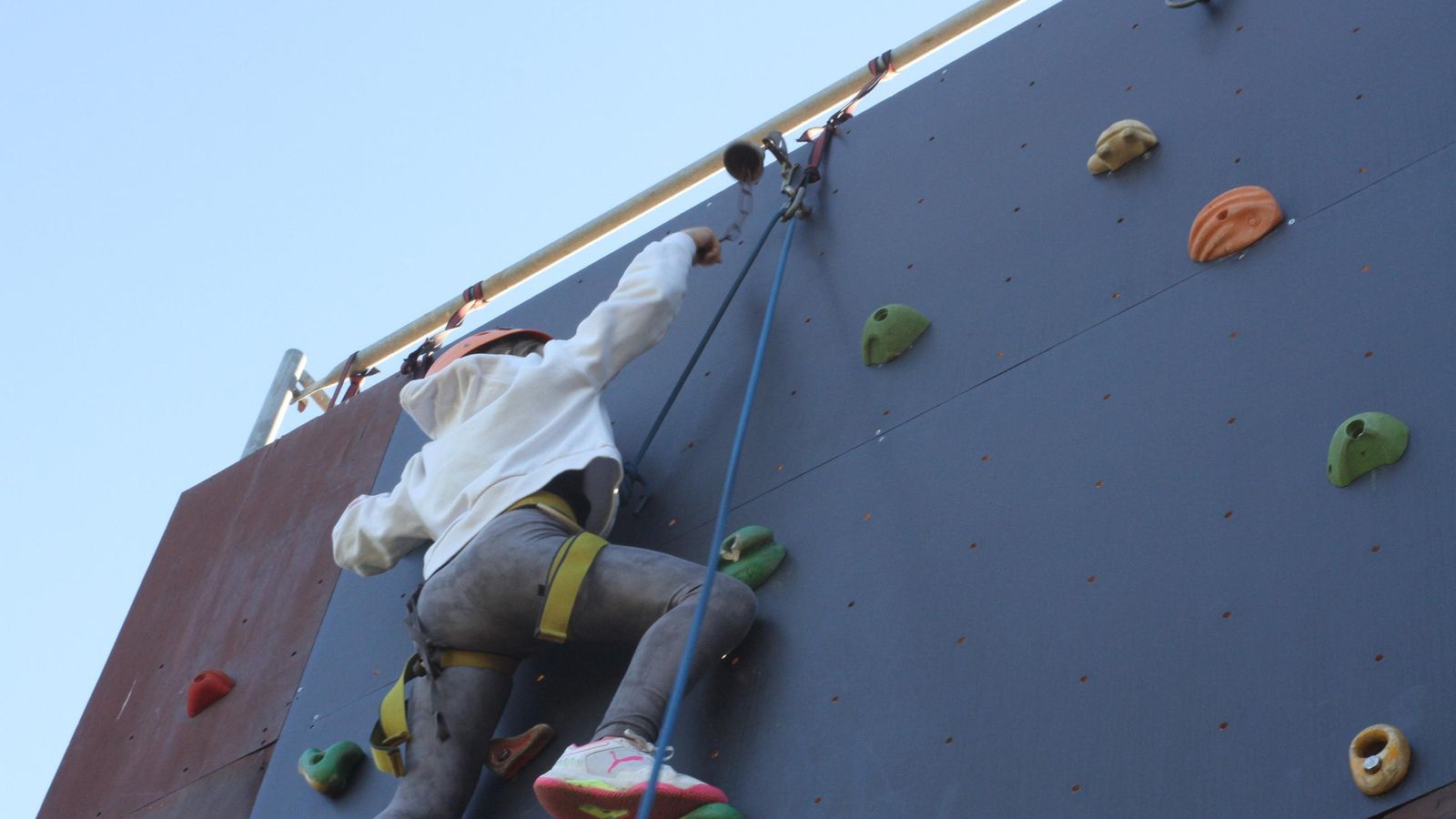 Uno de los niños escalando un rocodromo.
