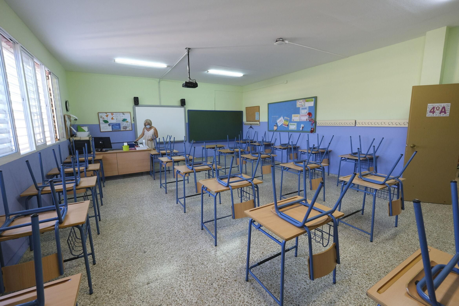 Una profesora en un aula de un colegio al terminar la clase.