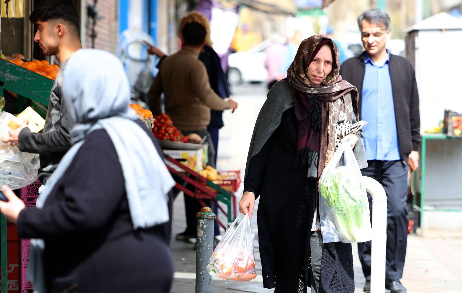 La vida sigue entre los habitantes de Teherán: compras, trabajos, pasear al perro...