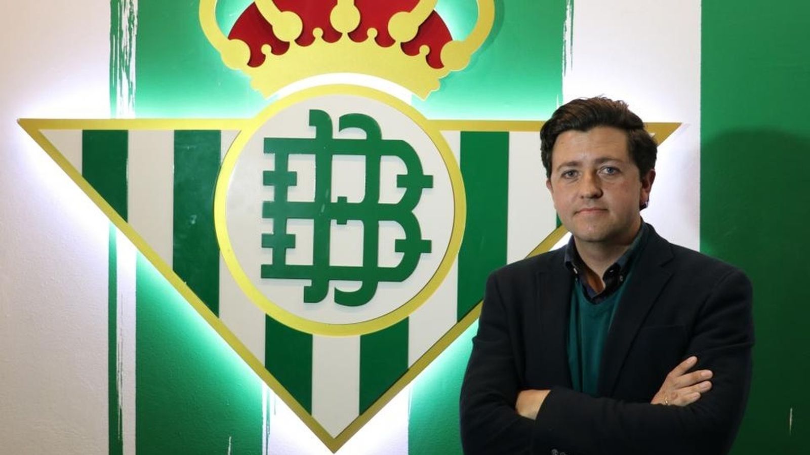 Miguel Calzado posa delante del escudo del Betis.