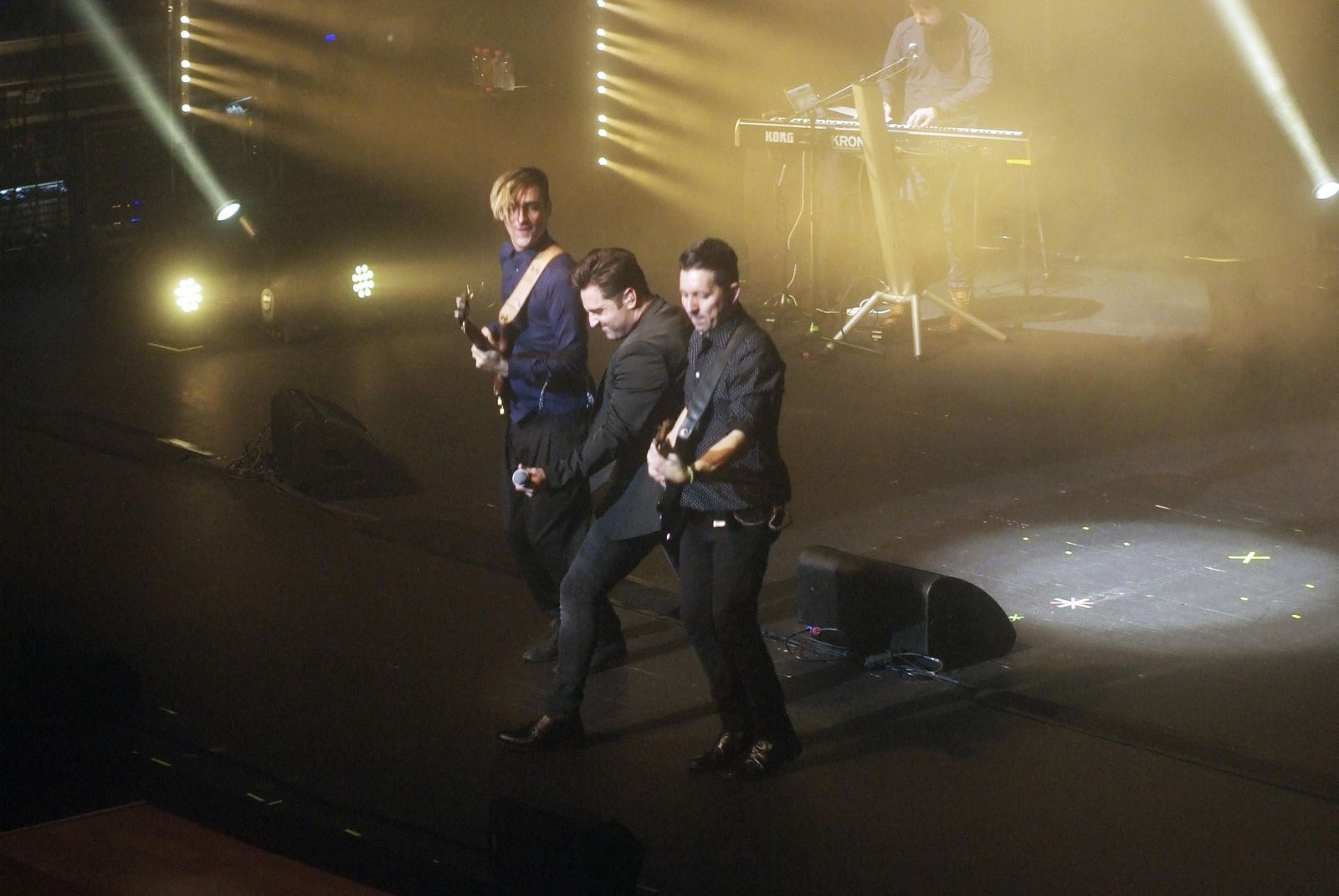 Bustamante acompañado de dos miembros de su banda al final del concierto.