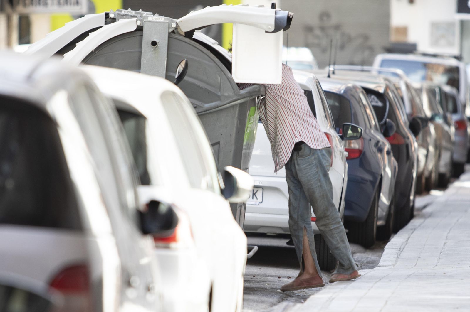 Una persona rebusca en un contenedor