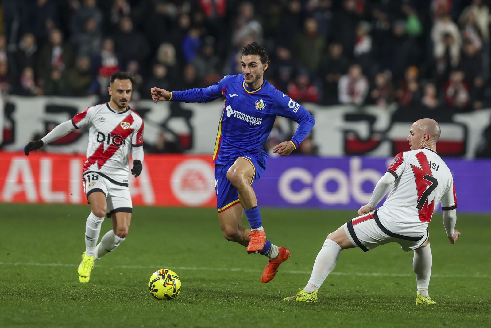 Juan Iglesias avanza entre Álvaro García e Isi en el Rayo-Getafe.