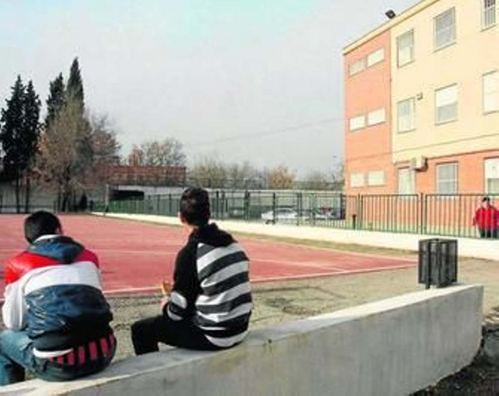 Dos alumnos del instituto La Paz de la Zona Norte de Granada descansan durante la hora del recreo.