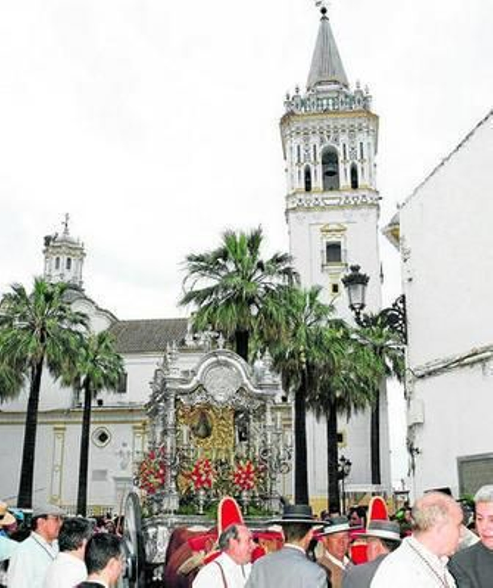 El Simpecado de La Palma del Condado, a su salida, con la bella torre de su iglesia custodiándolo.
