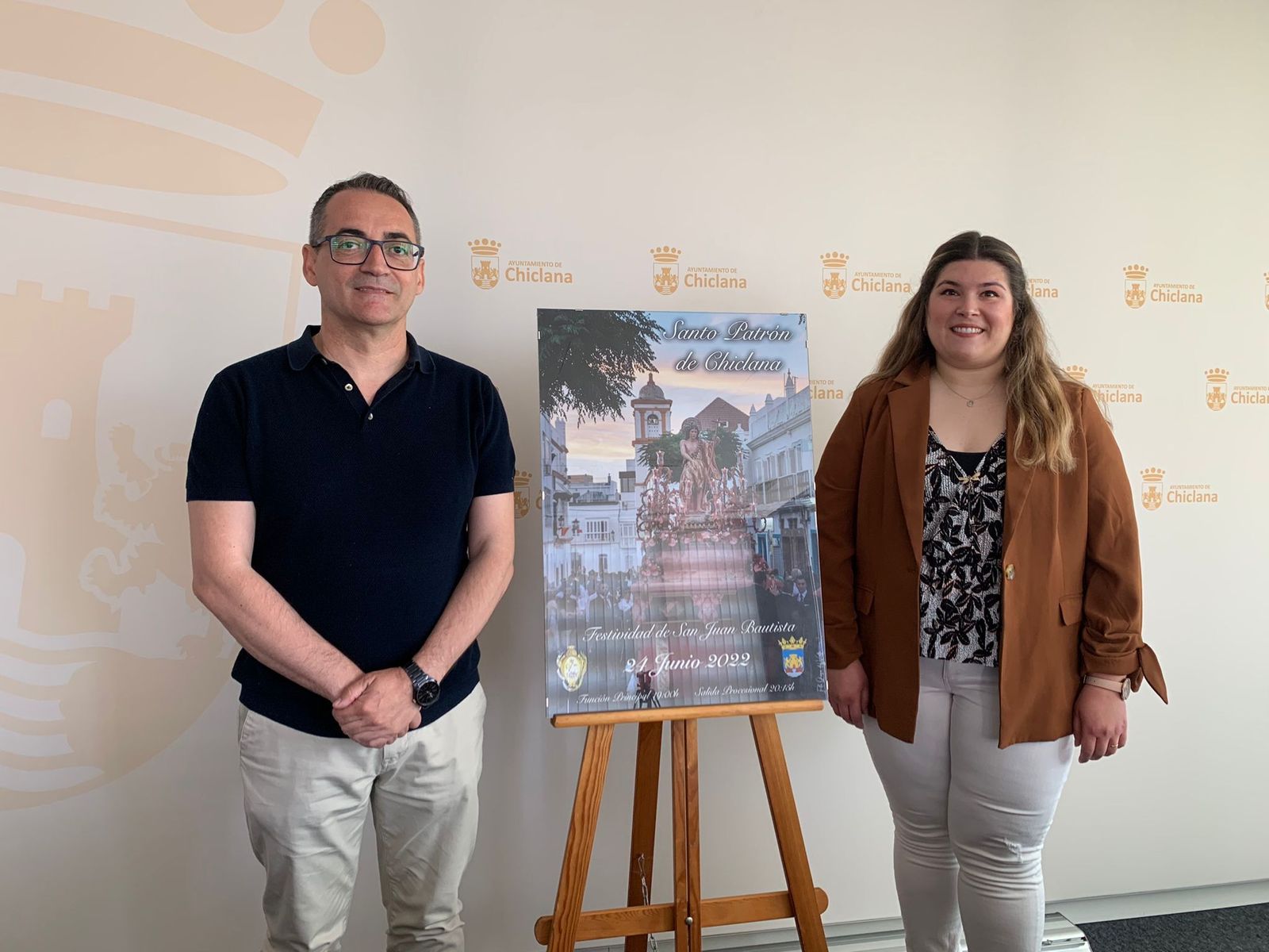 El teniente de alcalde, Francisco José Salado, y la vice-hermana mayor de la Hermandad Sacramental de San Juan Bautista, Elvira Cabeza de Vaca, presentan el cartel anunciador.