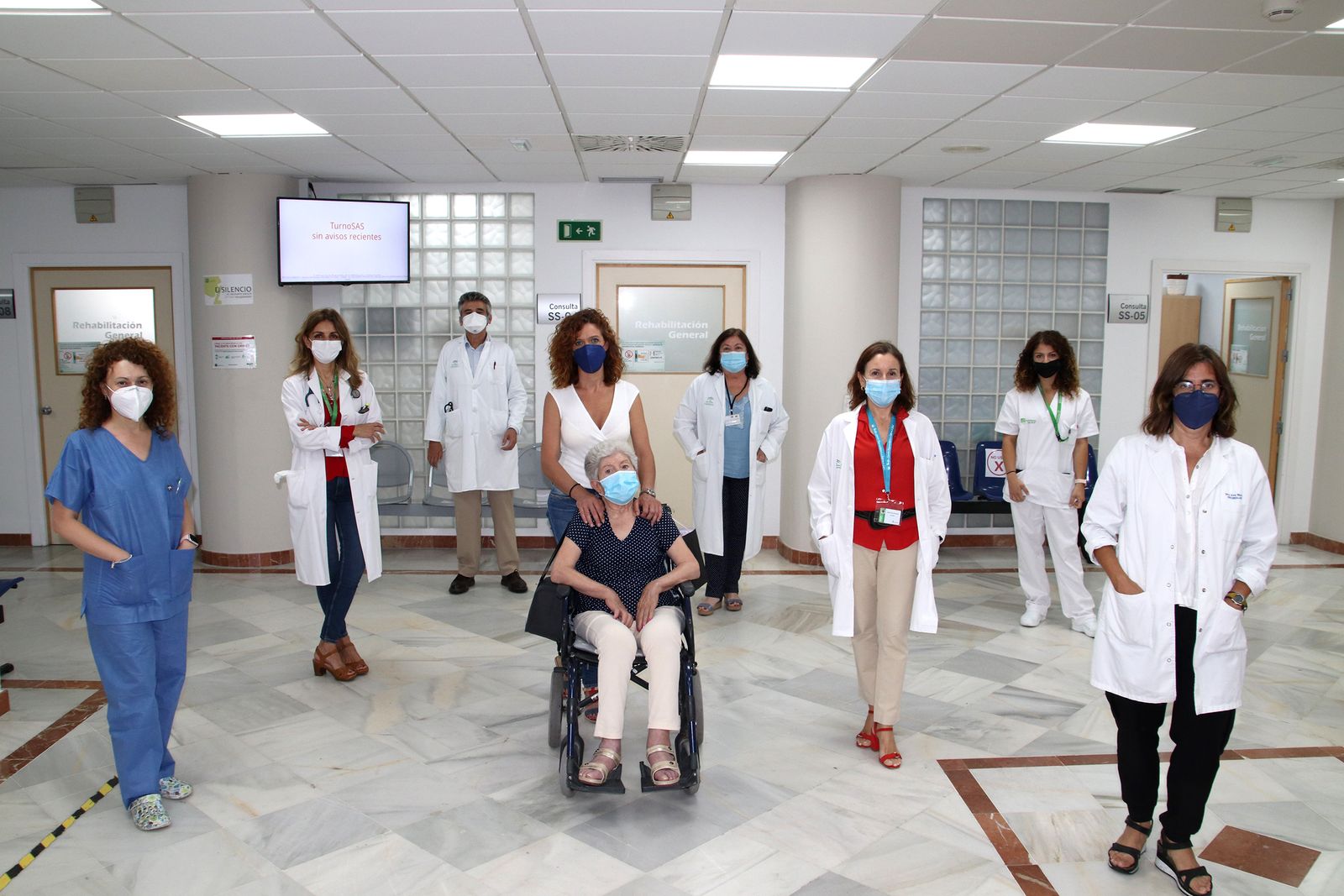 Miembros de la consulta multidisciplinar ELA con una paciente y su cuidadora.