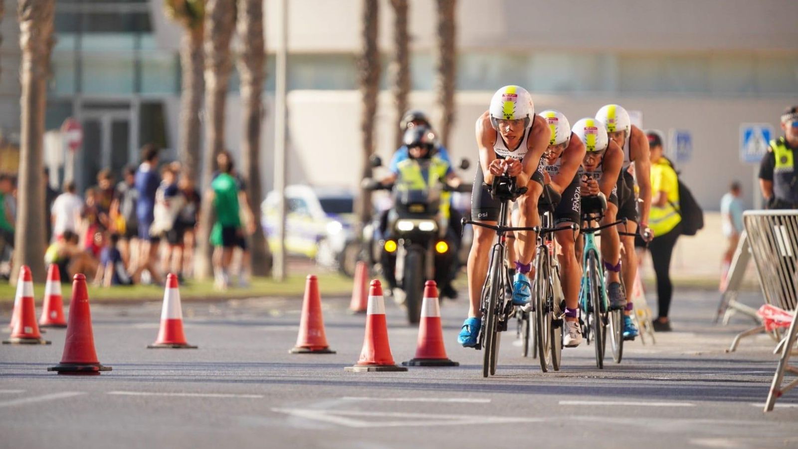 Uno de los conjuntos participantes a su paso en bicicleta por uno de los tramos del circuito de la prueba de Roquetas de Mar.