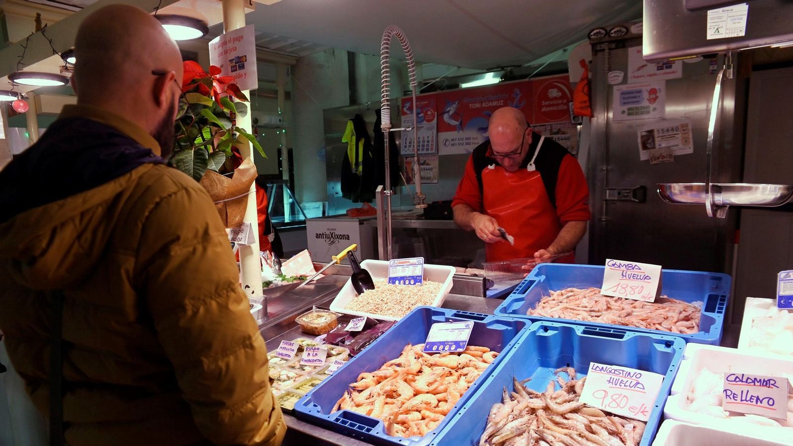 Un cliente le compra a Paco García en la pescadería Toñi Adamuz.