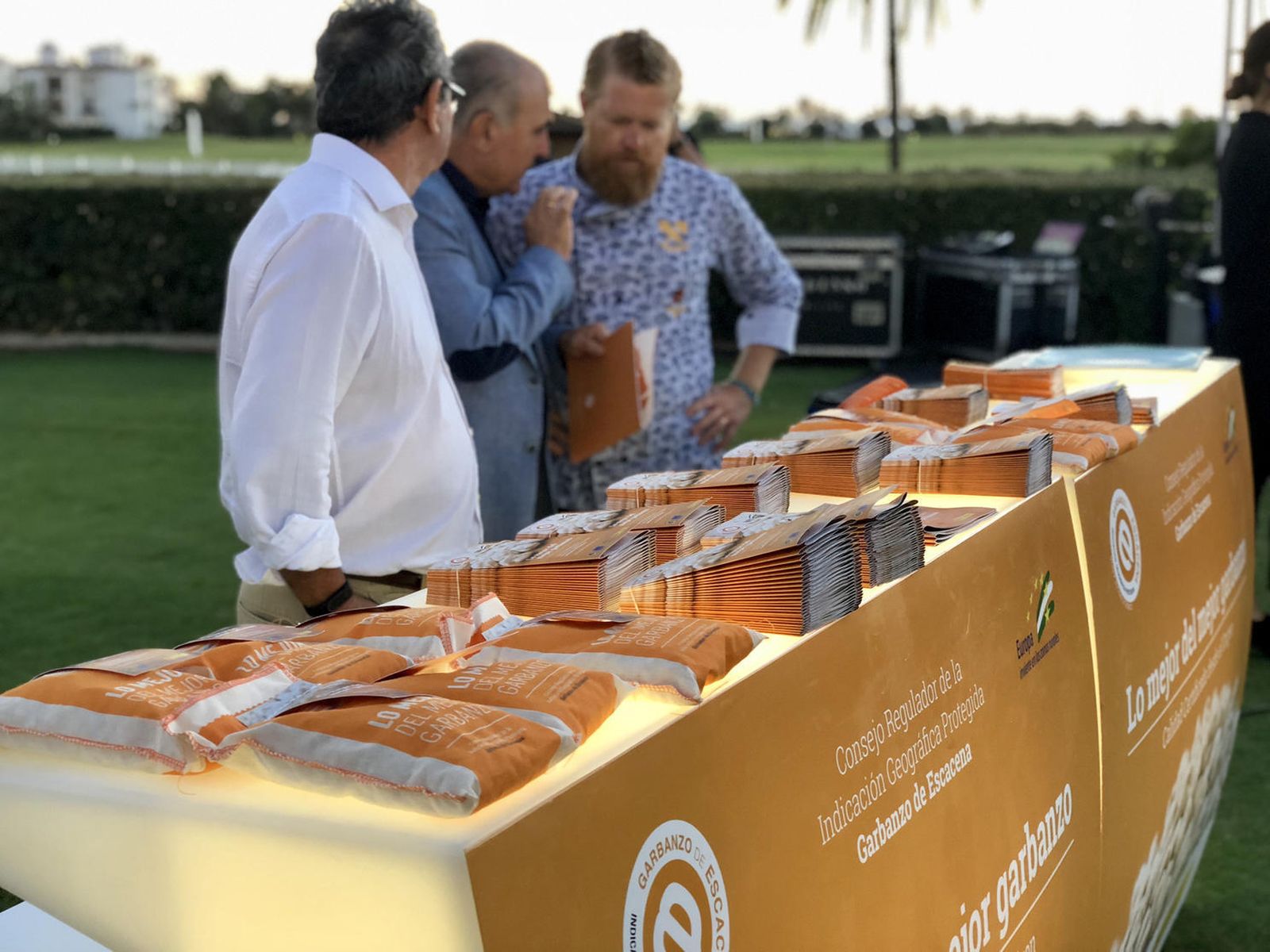 Los responsables de la IGP Garbanzo de Escacena en un expositor con la legumbre.