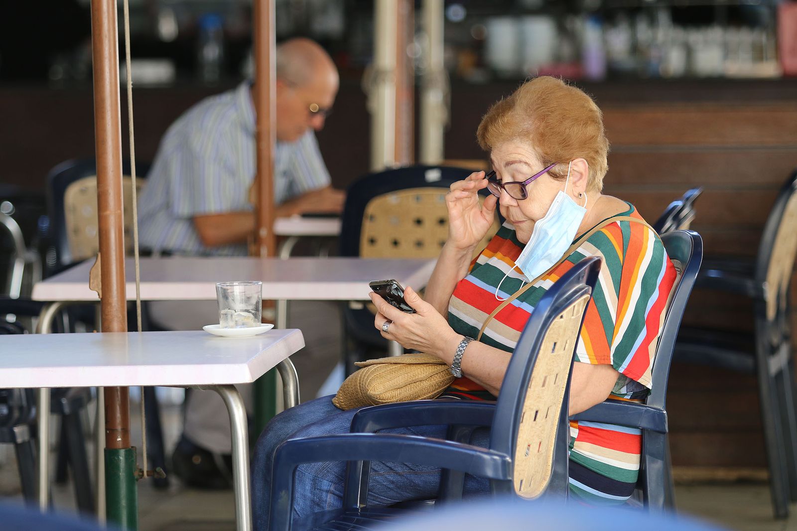 Una señora toma un café en un bar