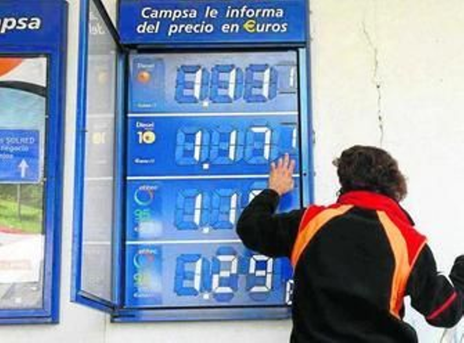 Una empleada de una gasolinera de Granada cambia los precios del combustible.