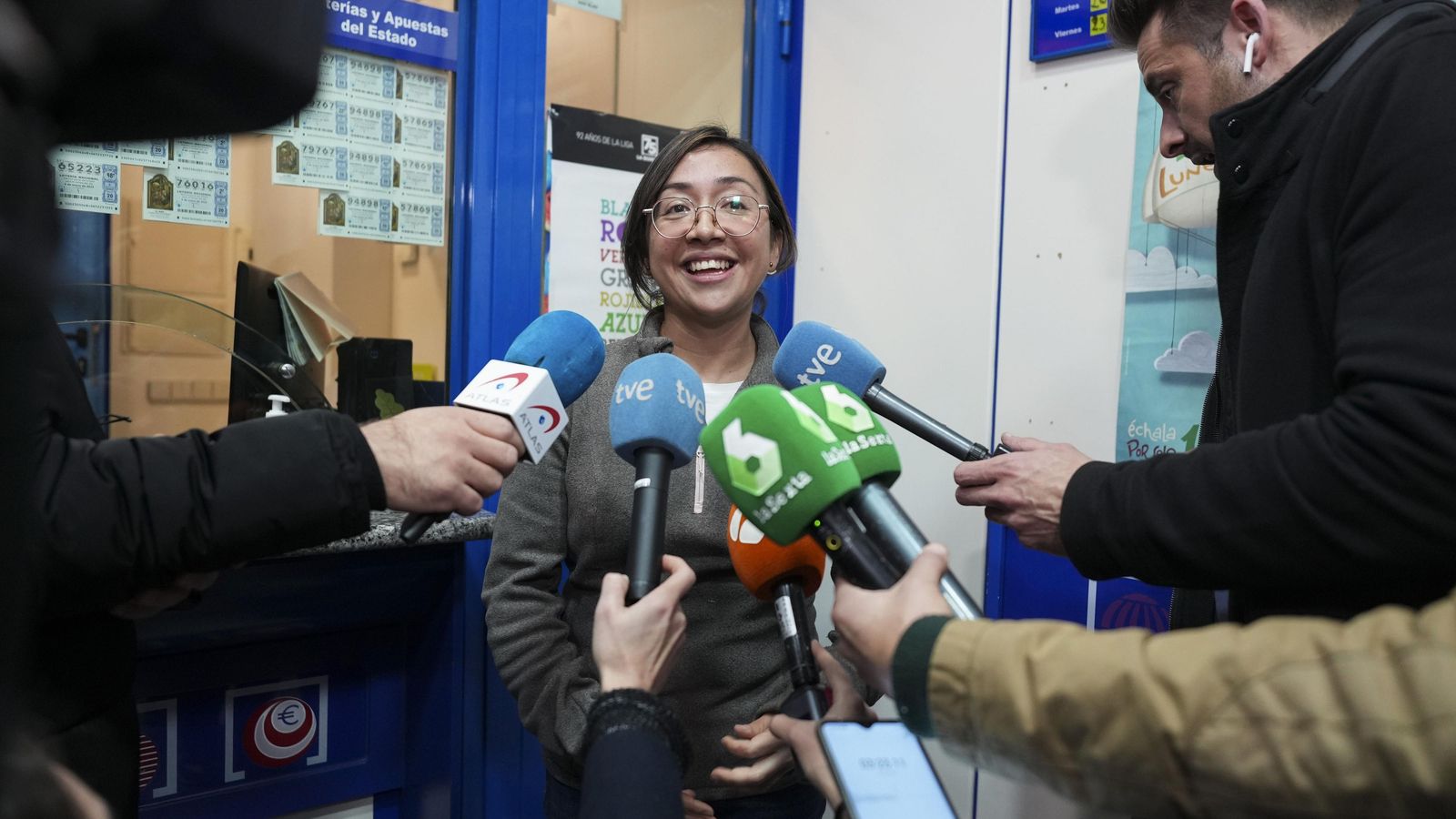 Yoana, encargada de la administración de Lotería Doña Juanita  situada en la calle Alcalá número 459 de Madrid, atiende a los medios después de que un número vendido en esta administración, el 45250, haya sido agraciado con el tercer premio de la Lotería de Navidad 2022.