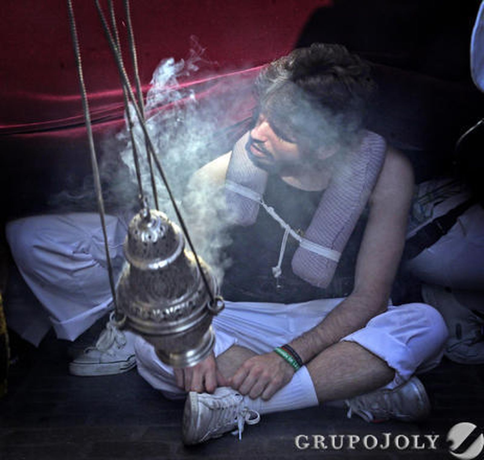 Un costalero de la Coronación sentado en el adoquinado una vez acabada la ‘chicotá’.  Foto: Miguel Angel Gonzalez