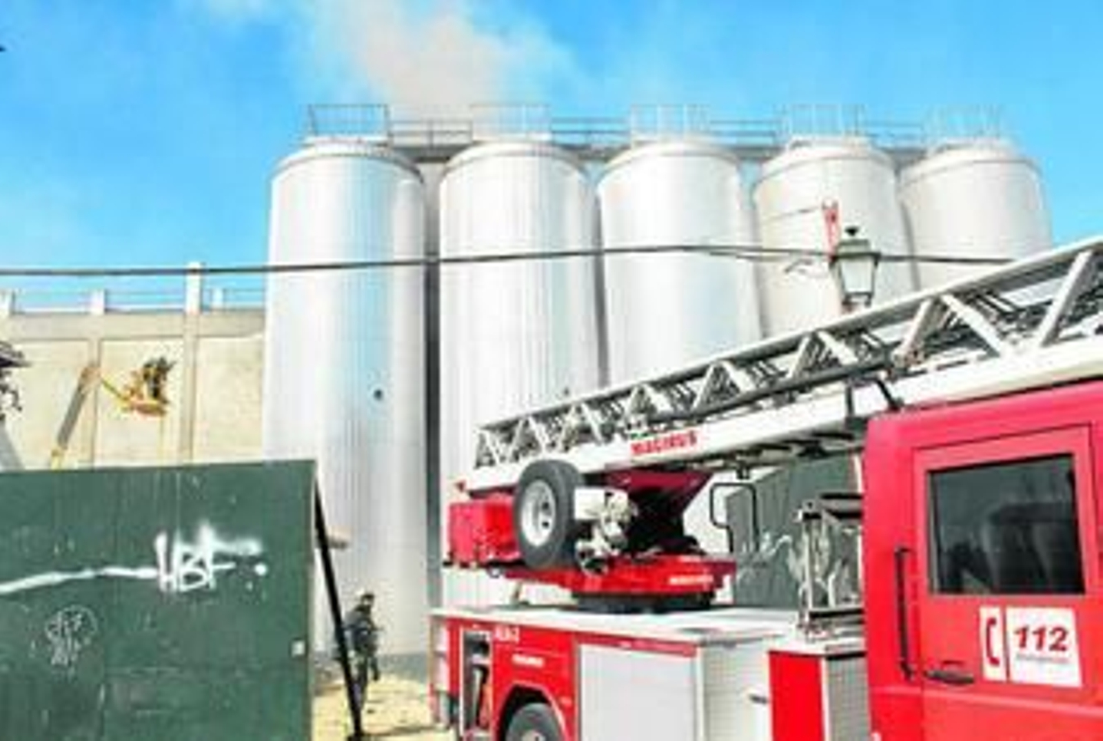 Los bomberos, durante la extinción del fuego en uno de los tanques de la empresa granadina.