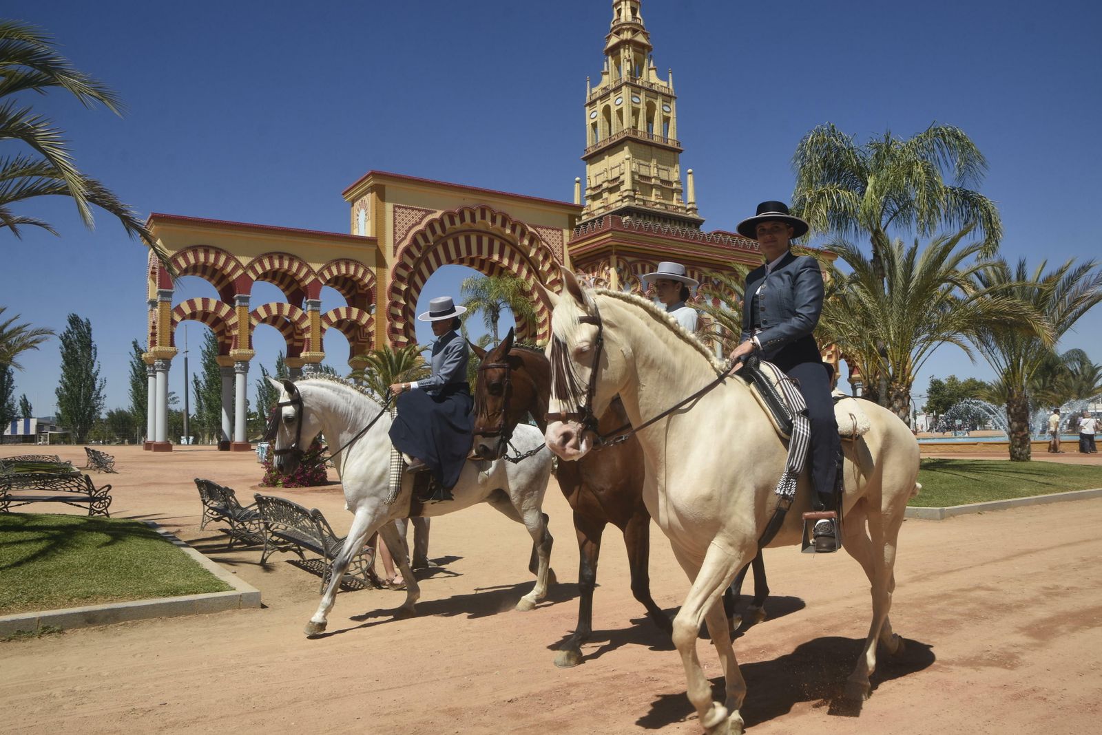 Unas amazonas pasan junto a la portada de Feria