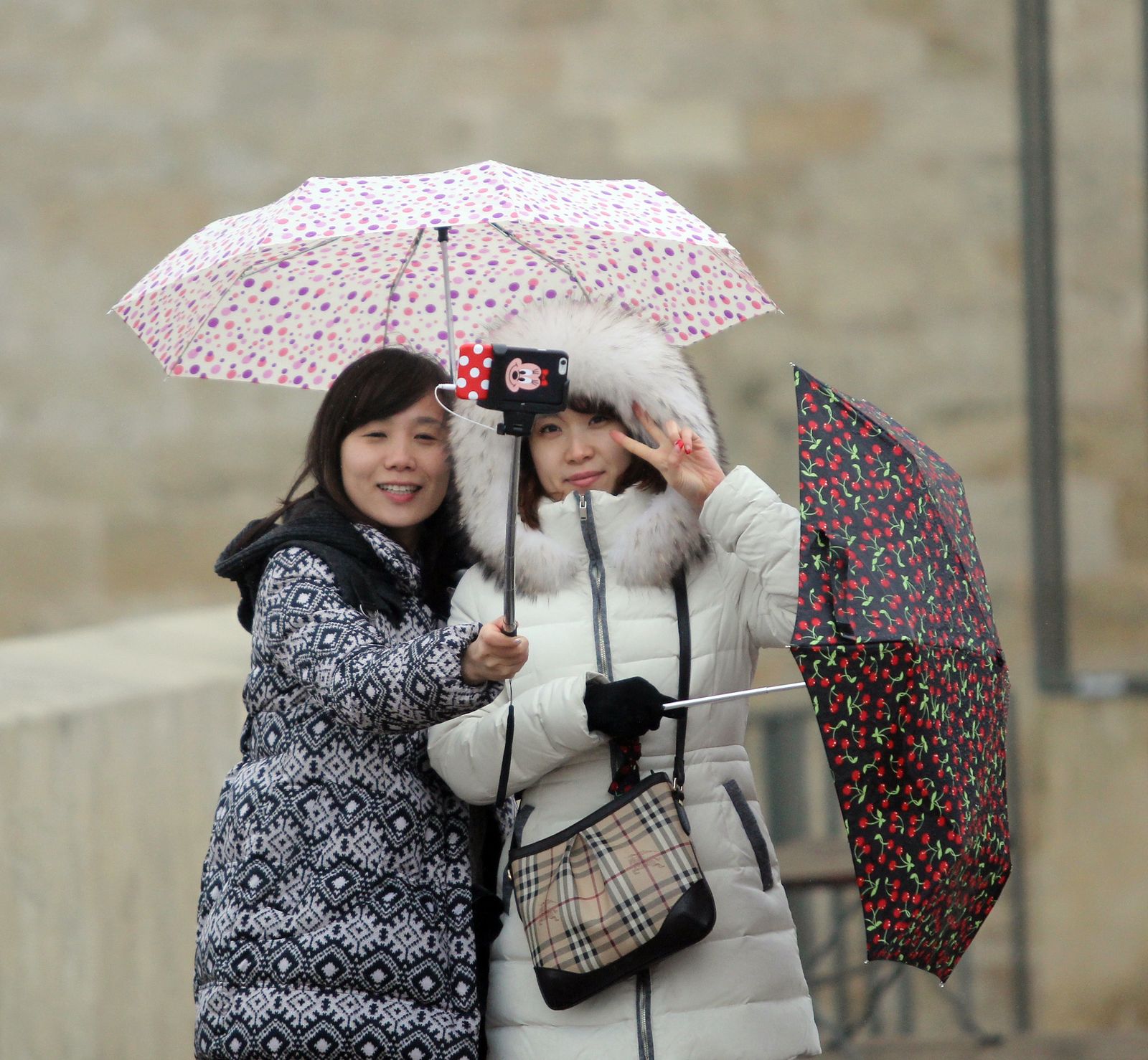 Imagen de archivo de dos turistas tomándose una foto bajo la lluvia en Córdoba.